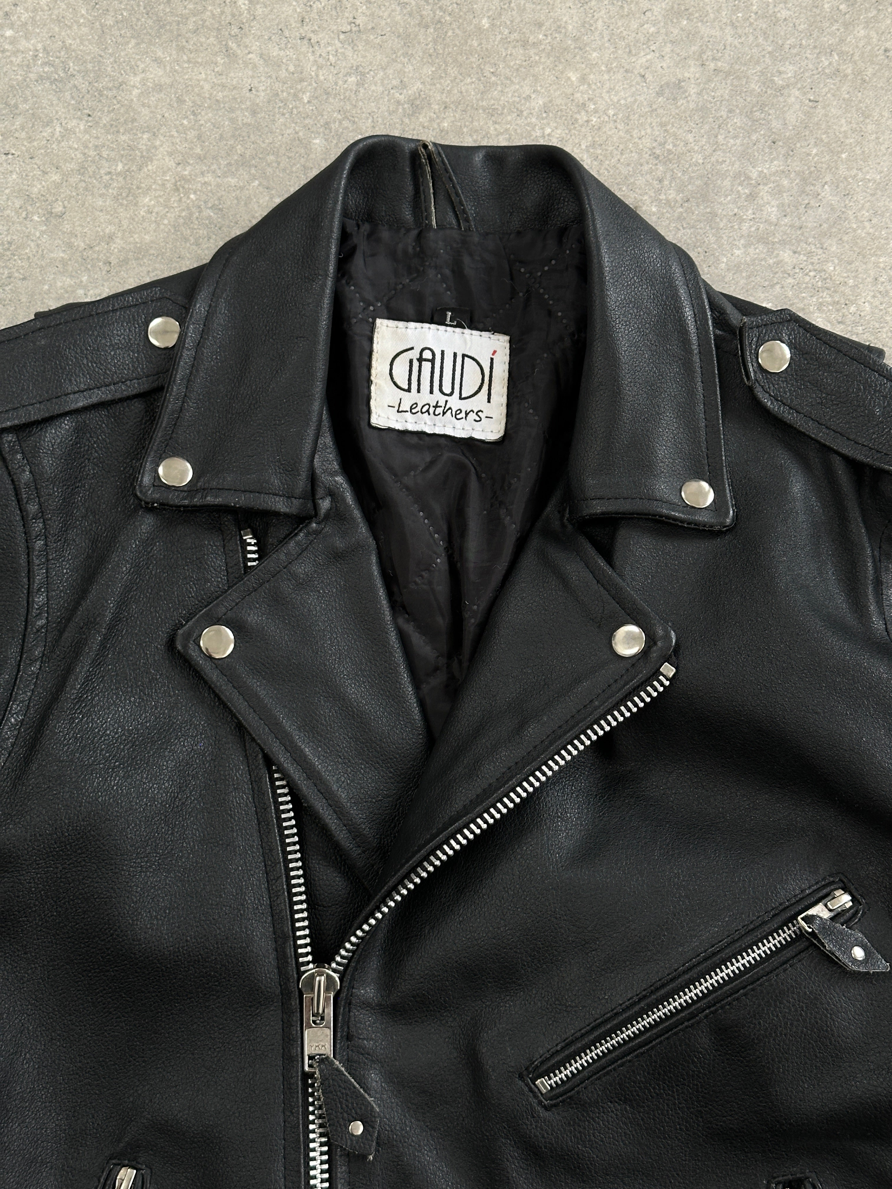 Vintage leather biker jacket in size M/L, featuring classic design and durable material, displayed on a hanger.