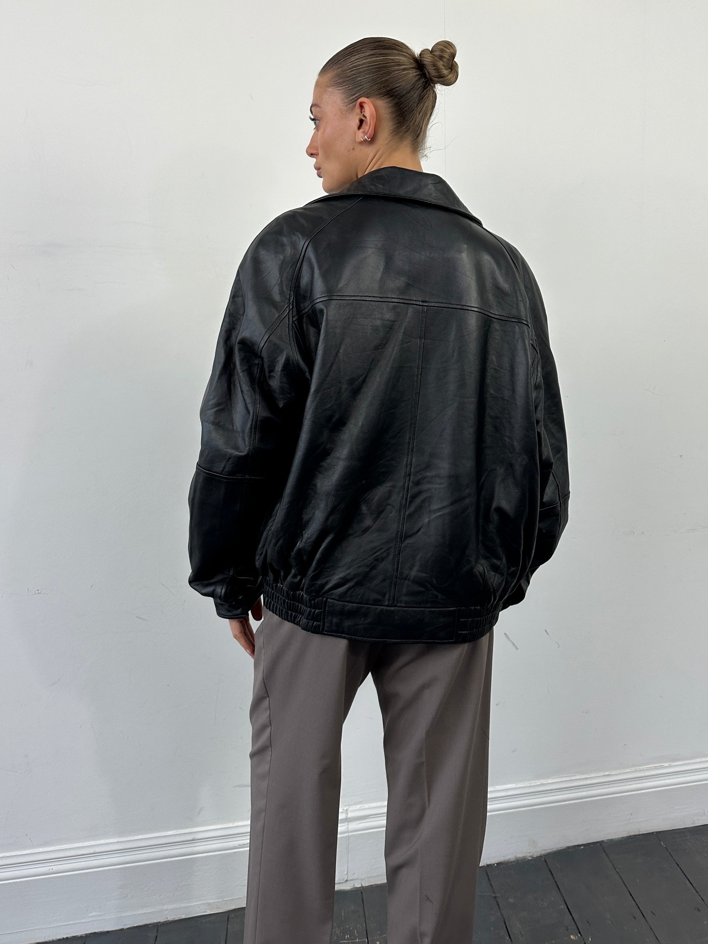 Vintage leather bomber jacket with vintage embroidery, size L/XL, featuring detailed stitched designs and a classic leather finish.