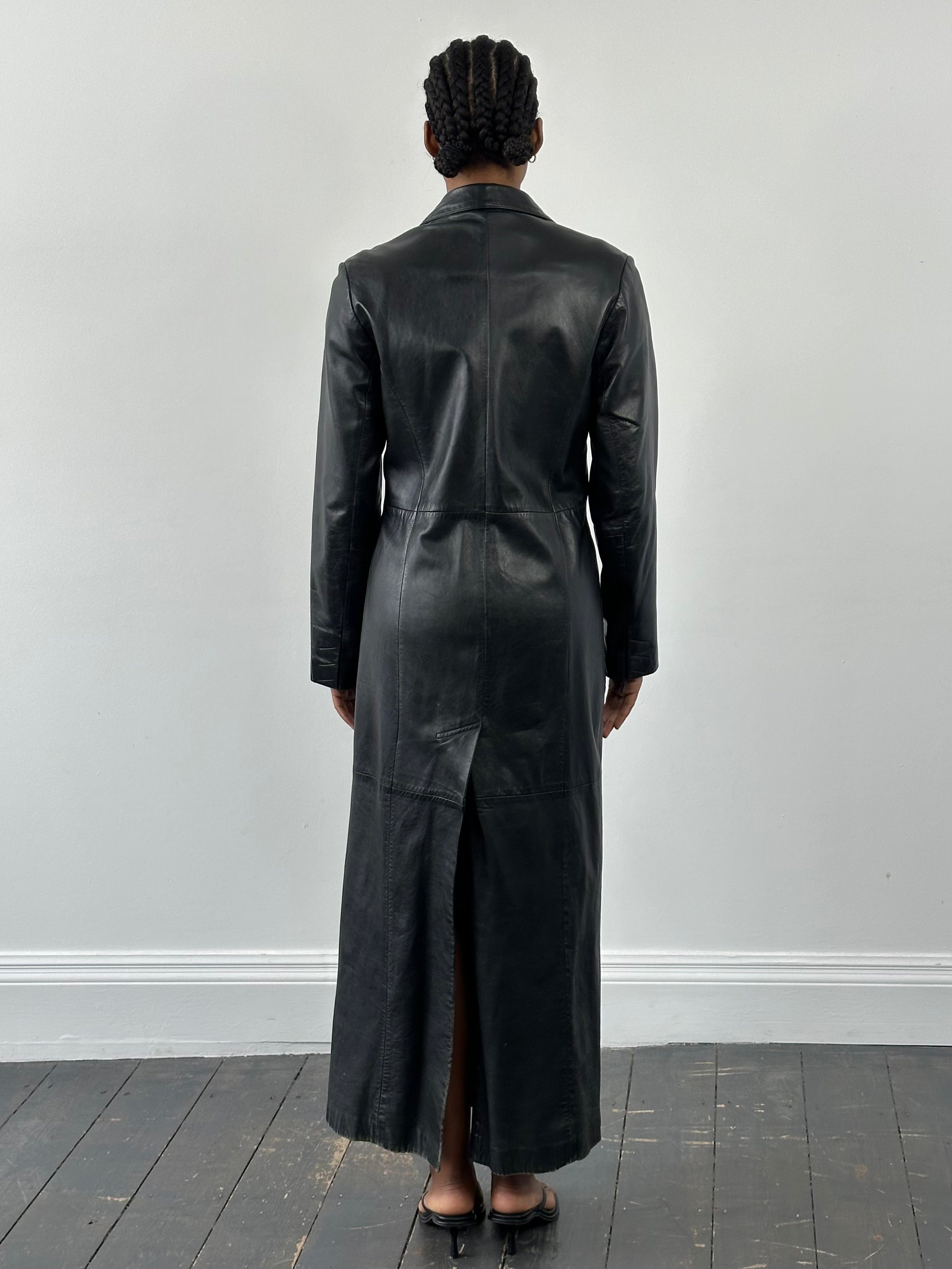 Vintage 1990s leather trench coat, floor length, with classic design and leather texture, in a stylish vintage leather jacket style.