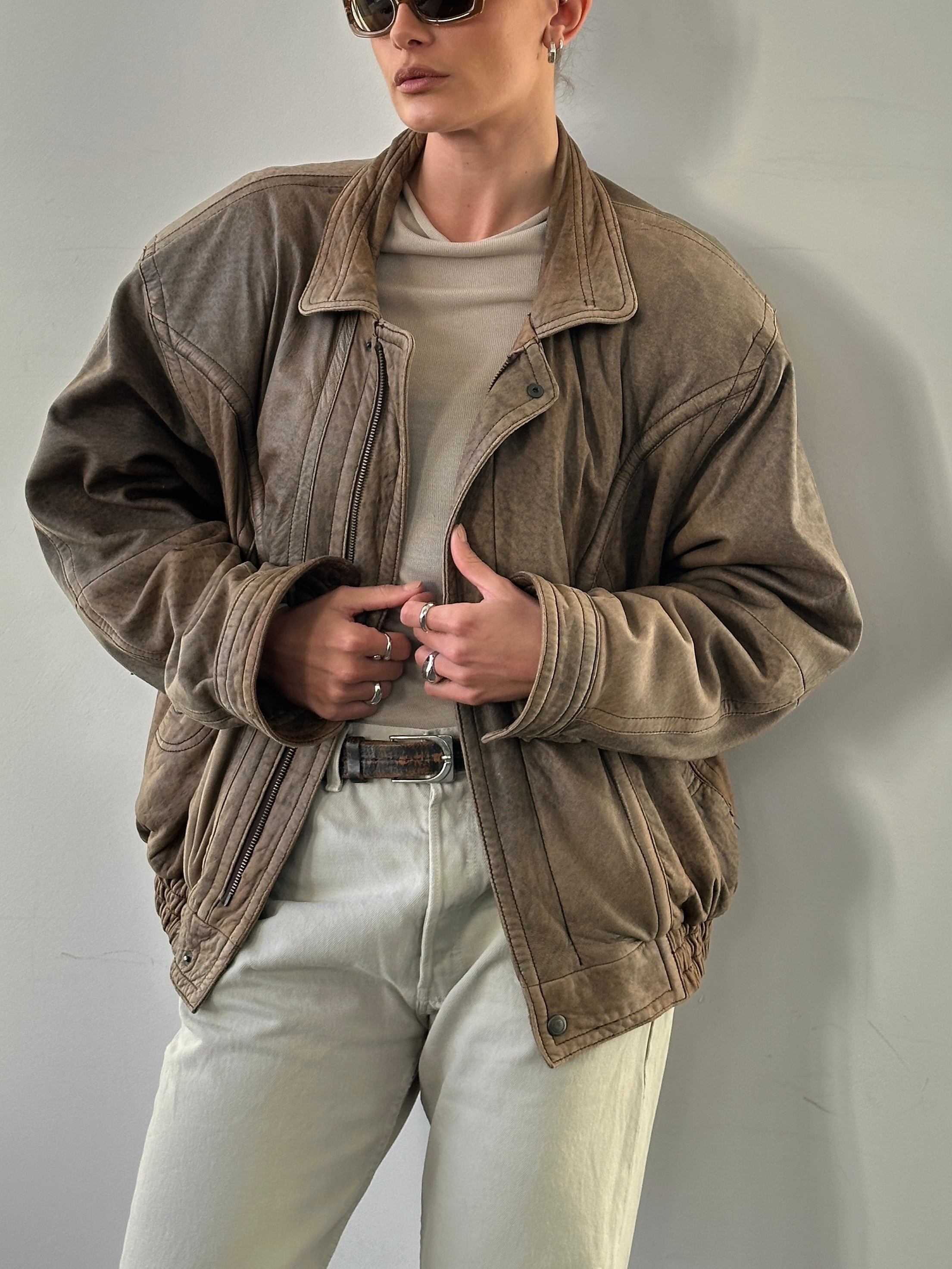 Vintage leather bomber jacket in size L/XL, featuring classic design and detailed stitching.