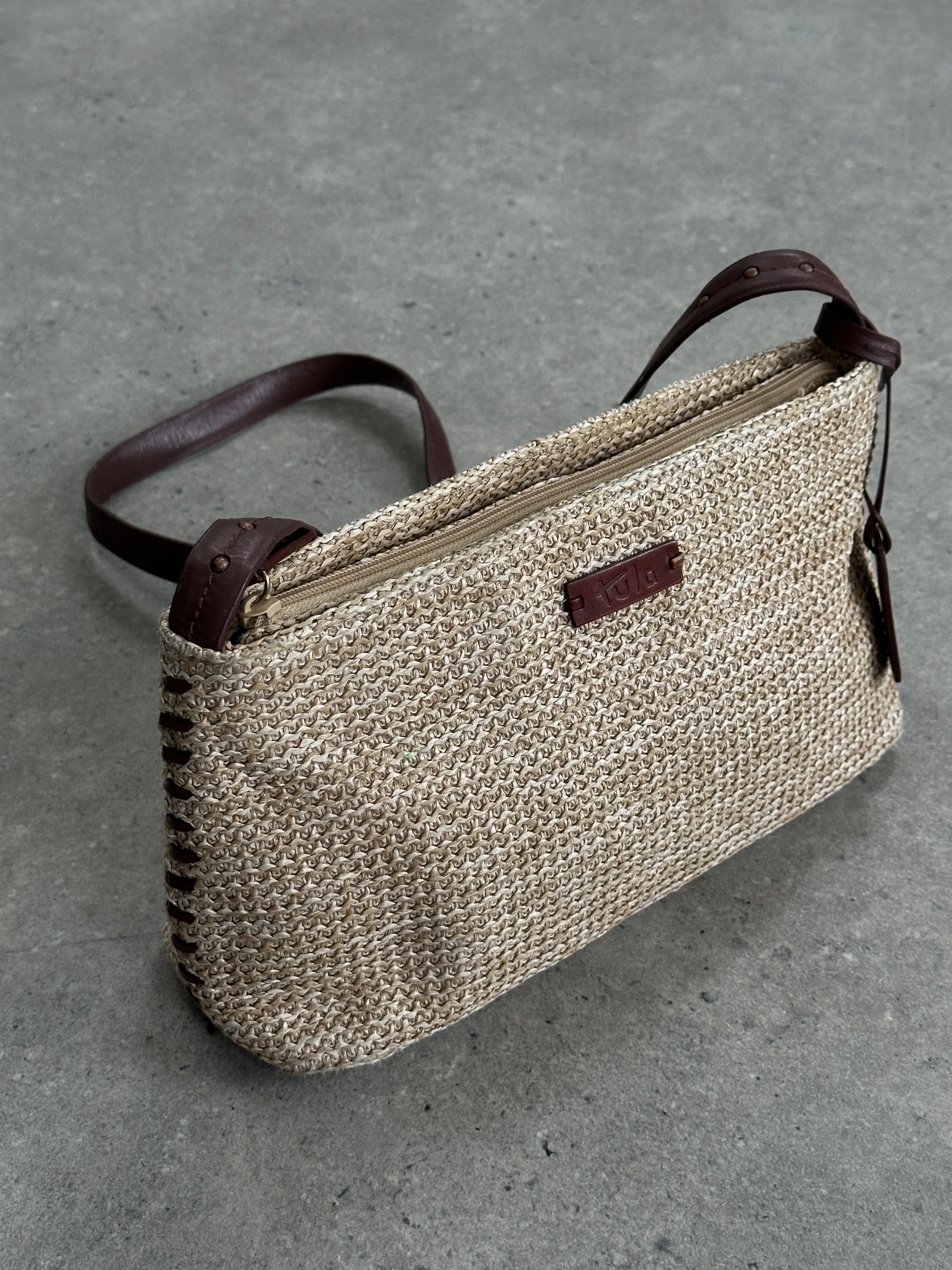 Vintage raffia crossbody bag with woven texture and adjustable strap, featuring a compact, stylish design for casual wear.