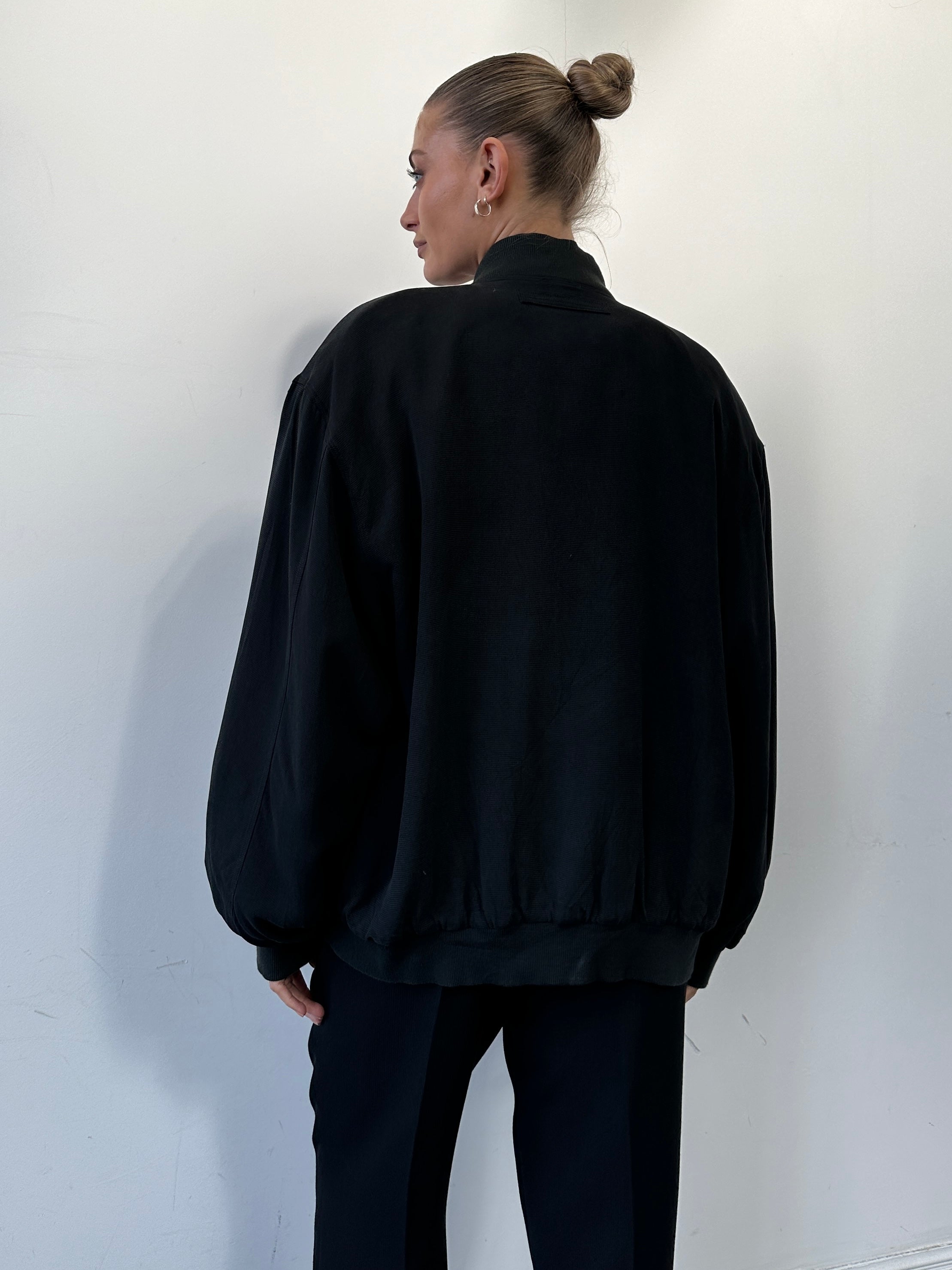 Vintage Italian pure silk bomber jacket in size L with classic design and smooth texture, displayed on a neutral background.