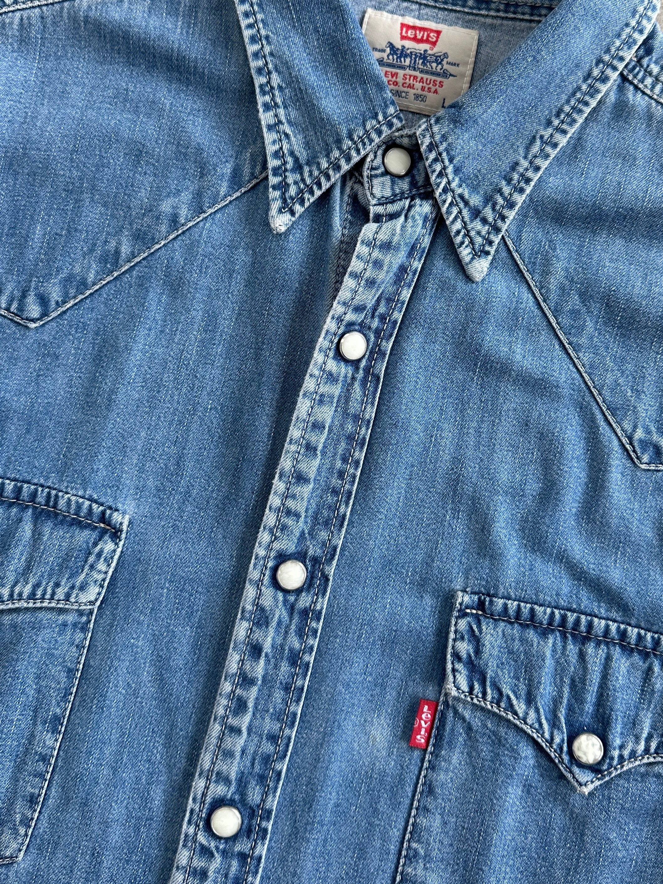 Levi’s cotton button-up denim shirt in size M, featuring classic blue denim fabric and chest pockets, casual men's shirt.