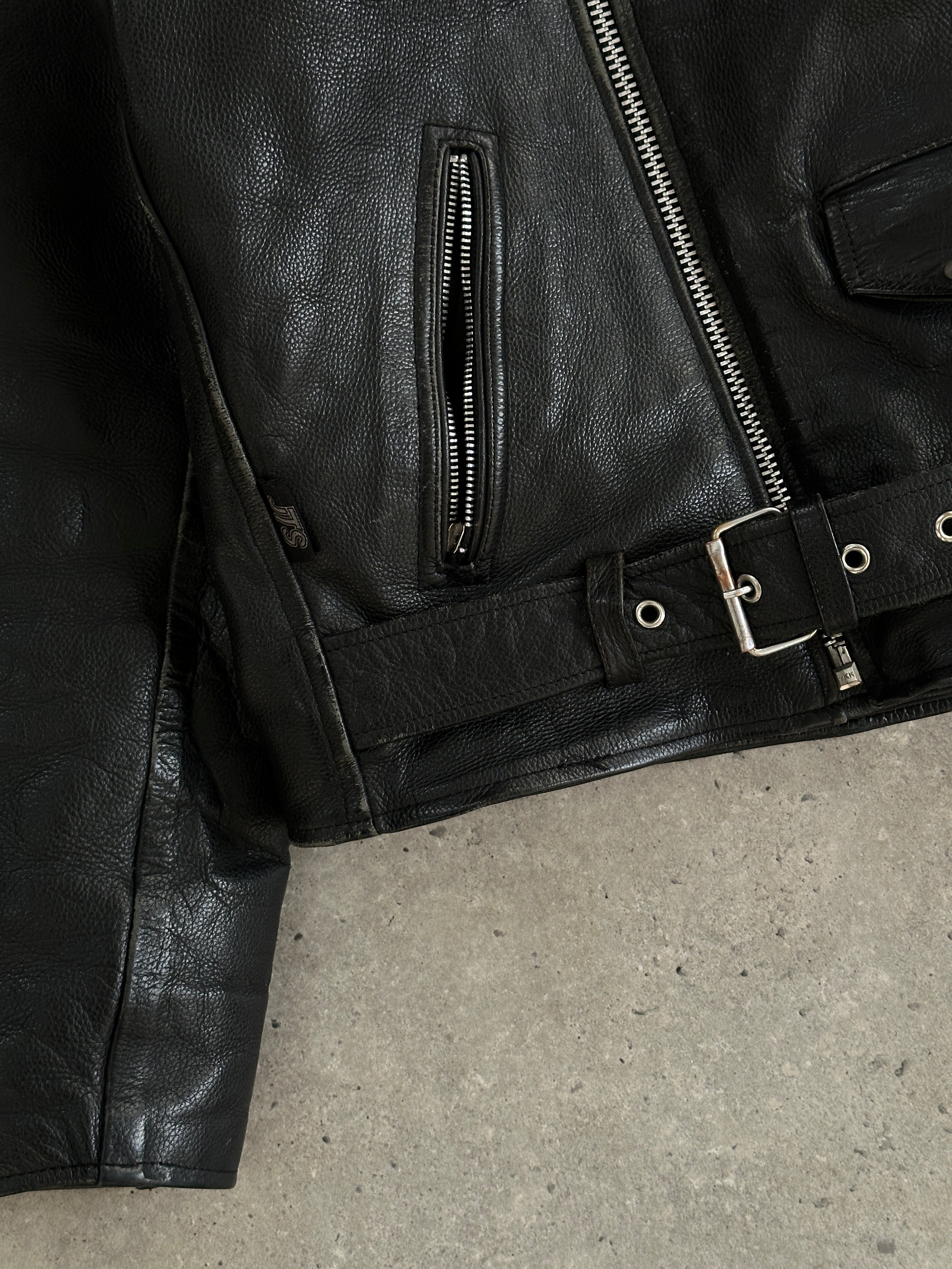 Vintage leather biker jacket in XL size, featuring classic design and durable material, displayed on a hanger.
