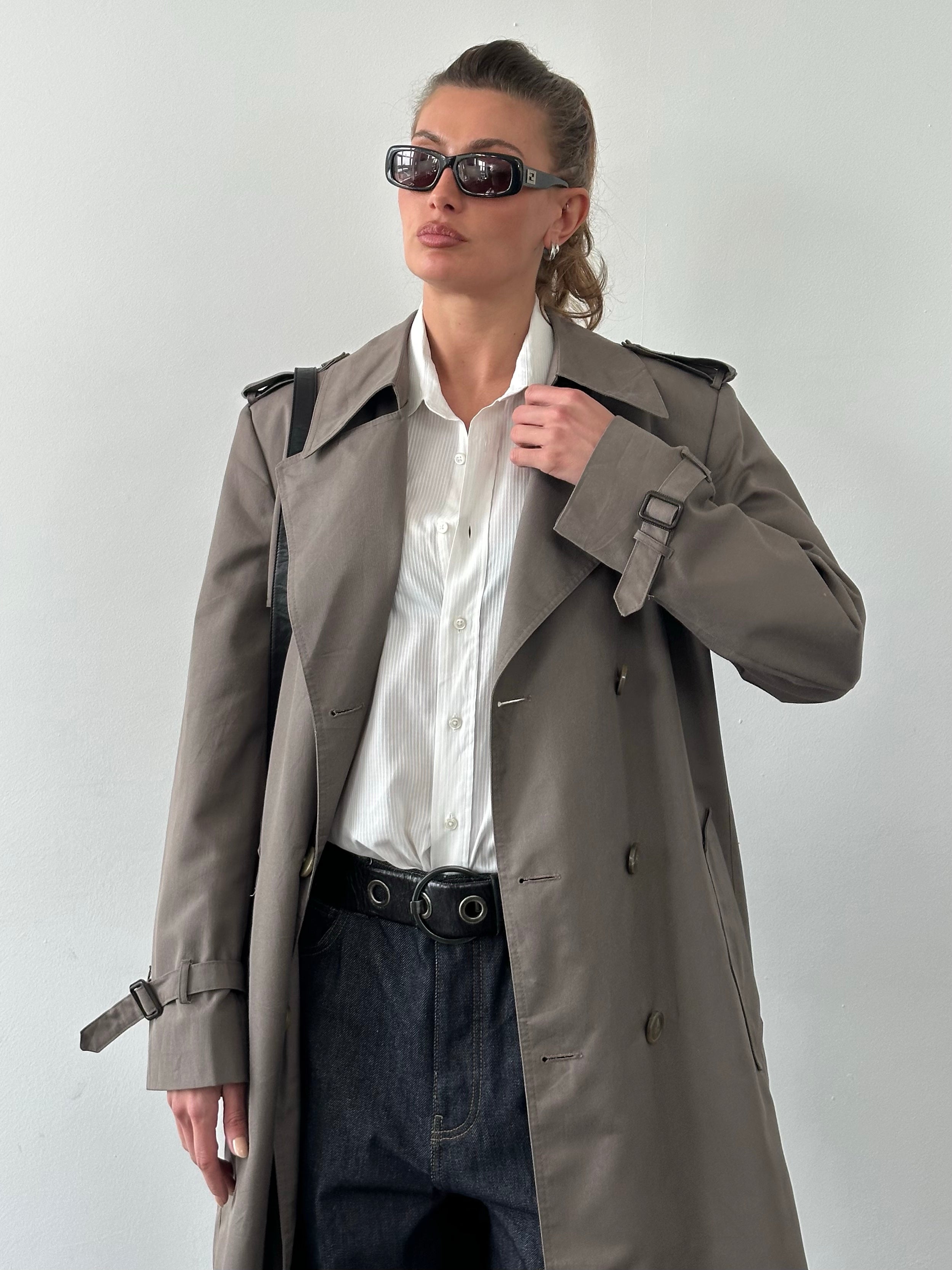 Christian Dior Monsieur 1980s double-breasted belted trench coat in beige, shown hanging with collar and belt detail.