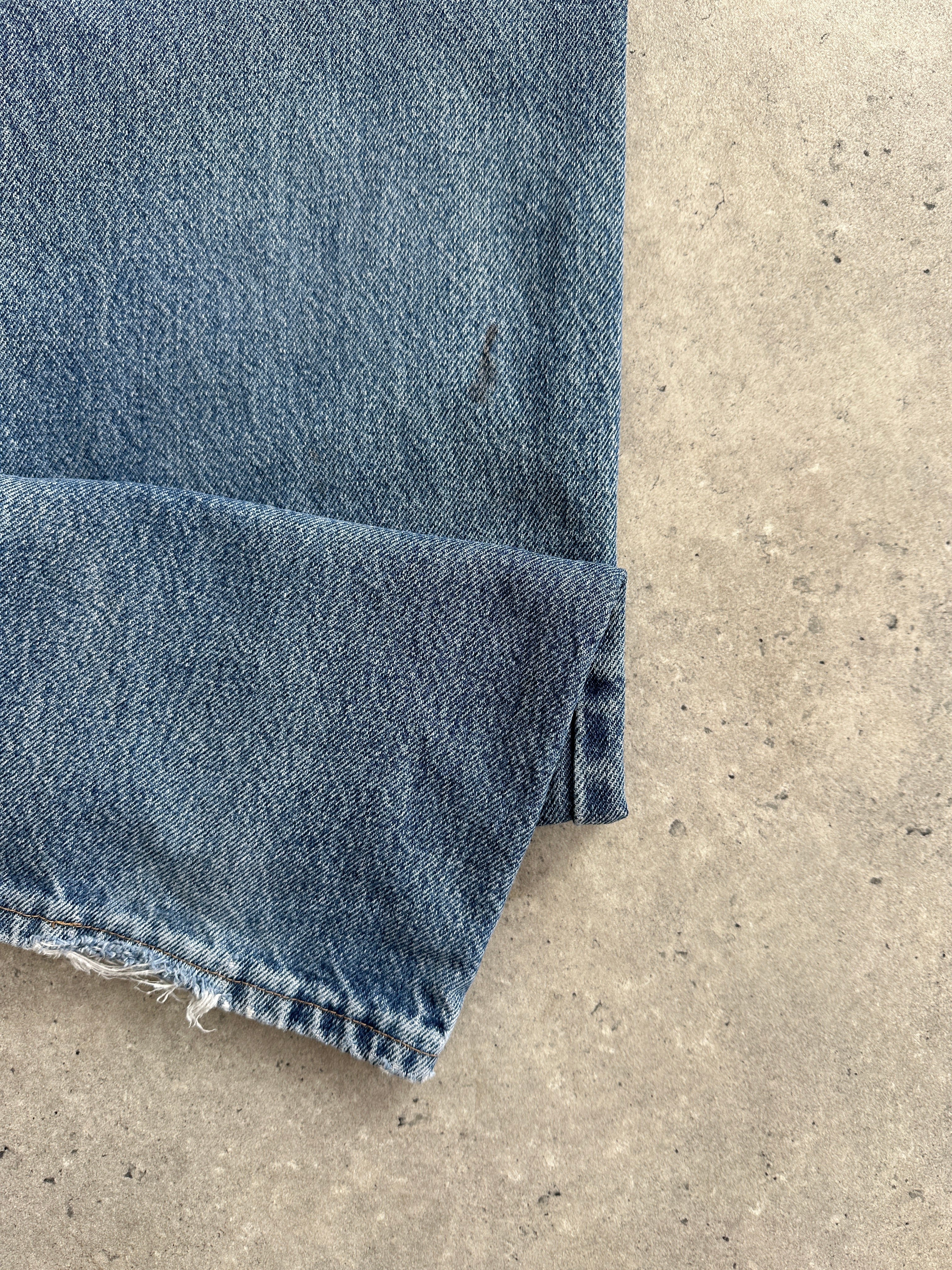 Wrangler mid wash straight leg high waisted denim jeans, W28, hanging on a hanger with visible pockets and stitching details.