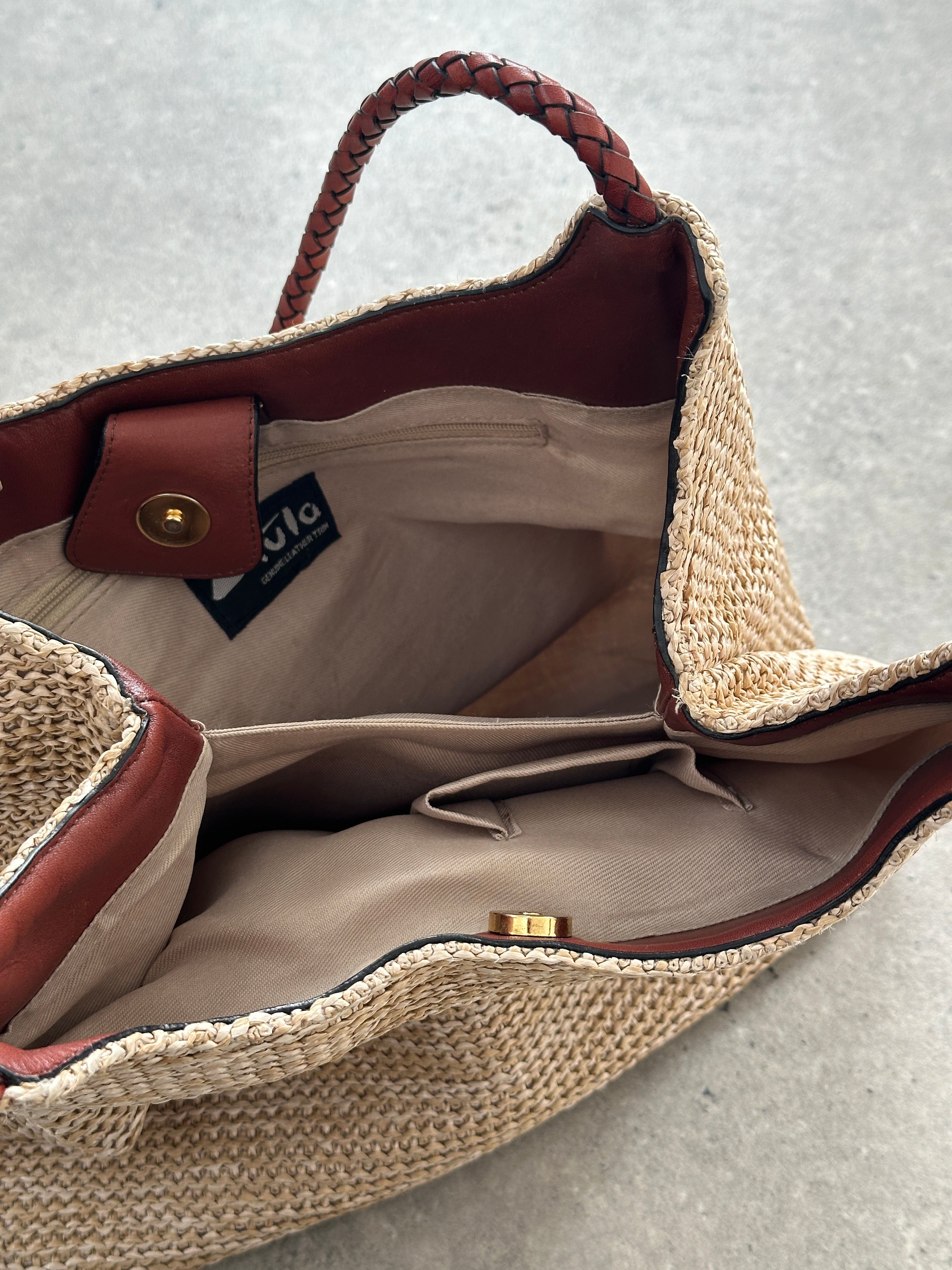 Vintage leather and straw shoulder bag with adjustable strap, featuring a rustic, bohemian style and classic design.