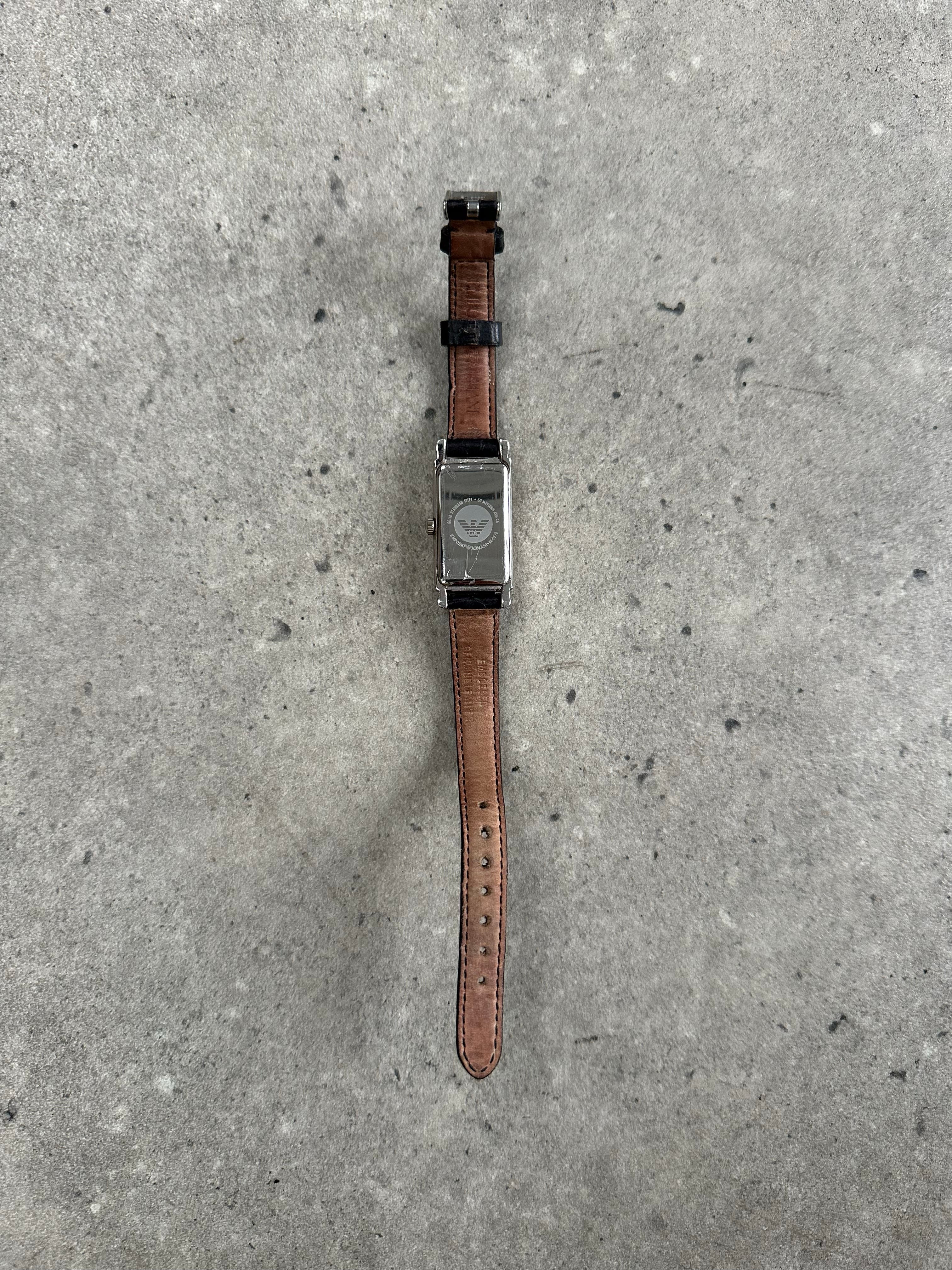 Emporio Armani 2000s leather watch with round face, silver dial, and black leather strap, showcasing classic luxury style.