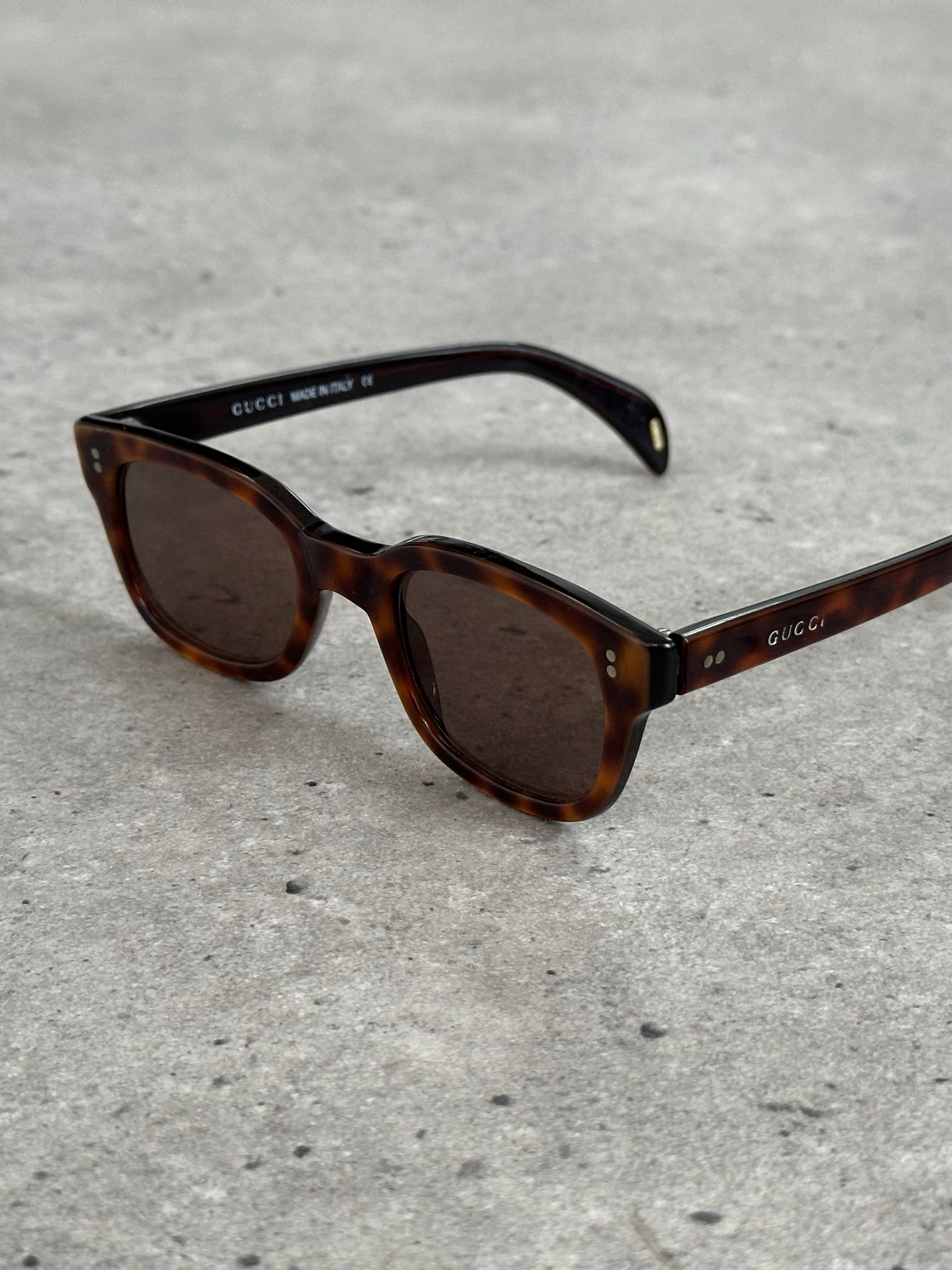 Gucci 2000s Tom Ford tortoiseshell rectangle logo sunglasses with bold frames and classic design, reflecting vintage luxury style.