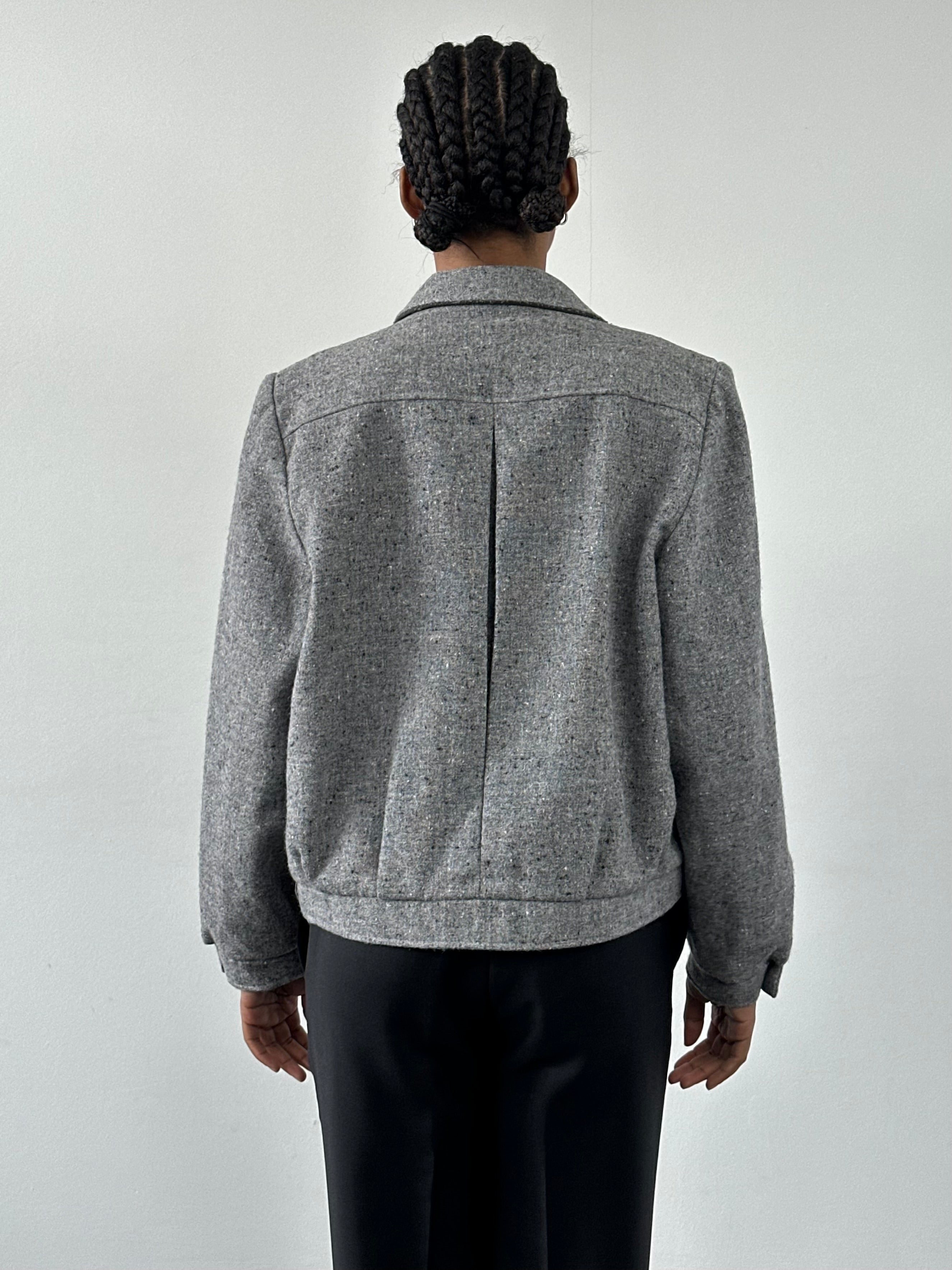 Vintage British 1980s pure wool bomber jacket, size M, with classic design and textured fabric, displayed on a hanger.