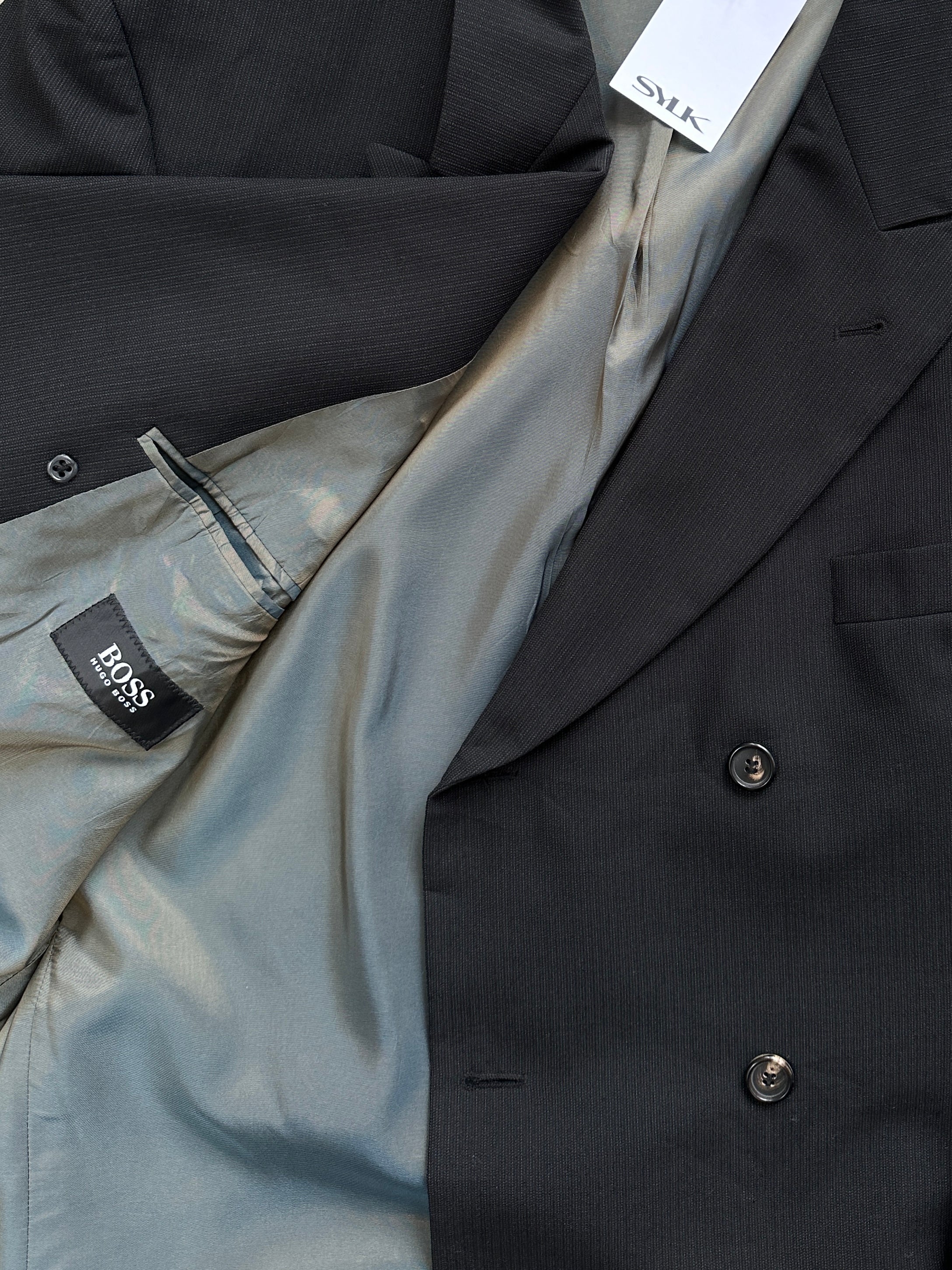 Hugo Boss double-breasted pure wool blazer in XXL, tailored fit with notch lapels and button closure, styled on a hanger.