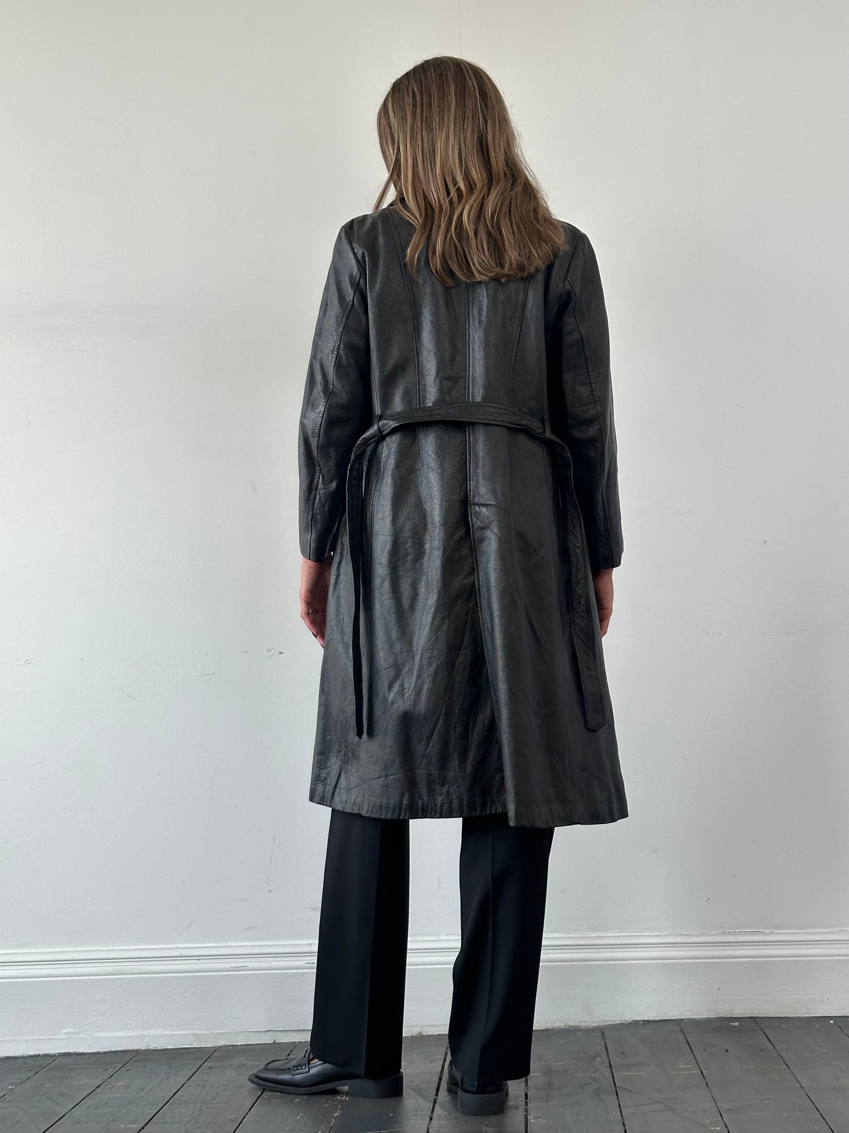 Vintage leather trench coat with belted waist, classic design, in size M/L, featuring a stylish leather jacket look.