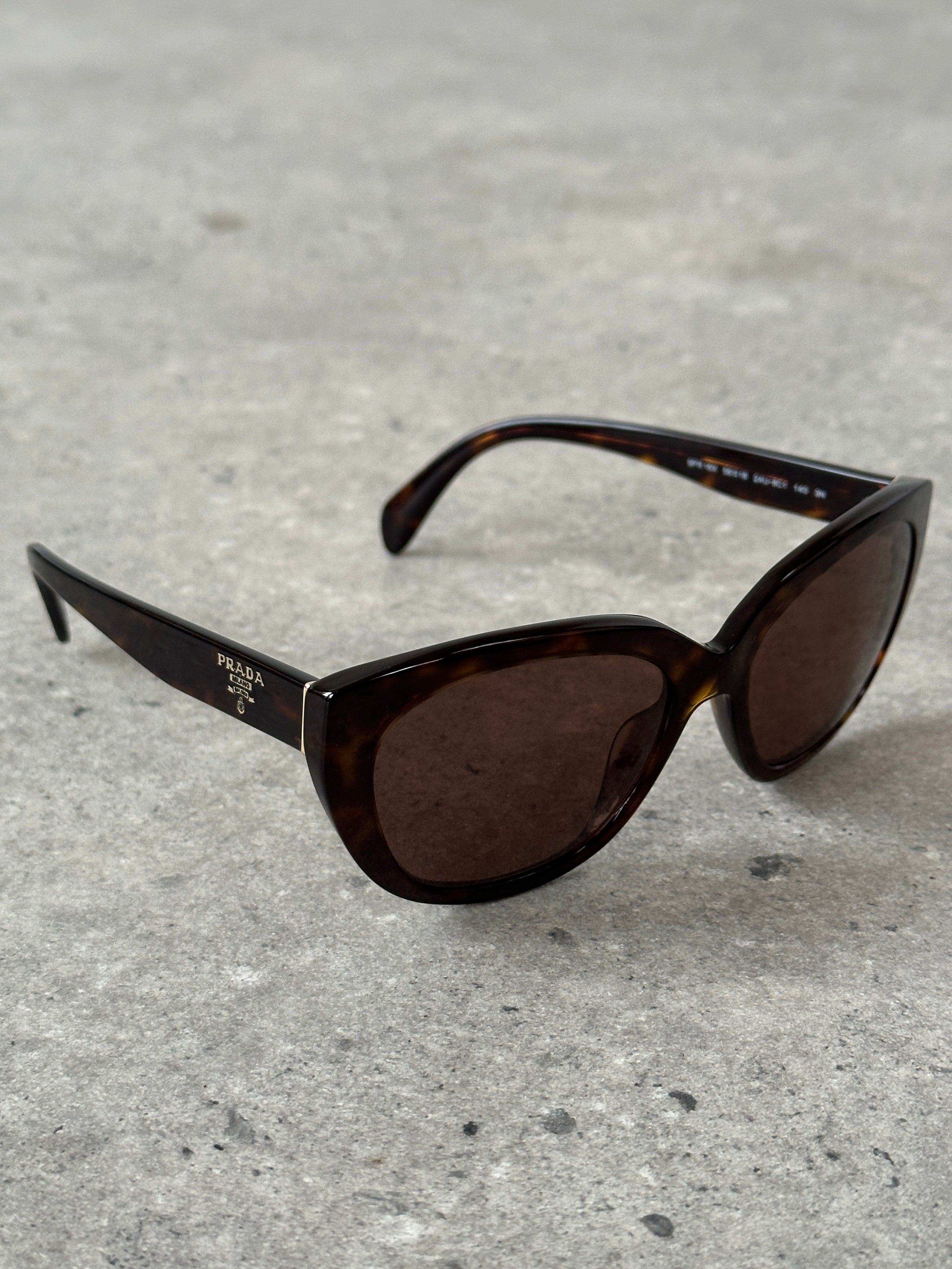 Prada tortoise shell round logo sunglasses with dark lenses and sleek frame, stylish eyewear for sun protection.