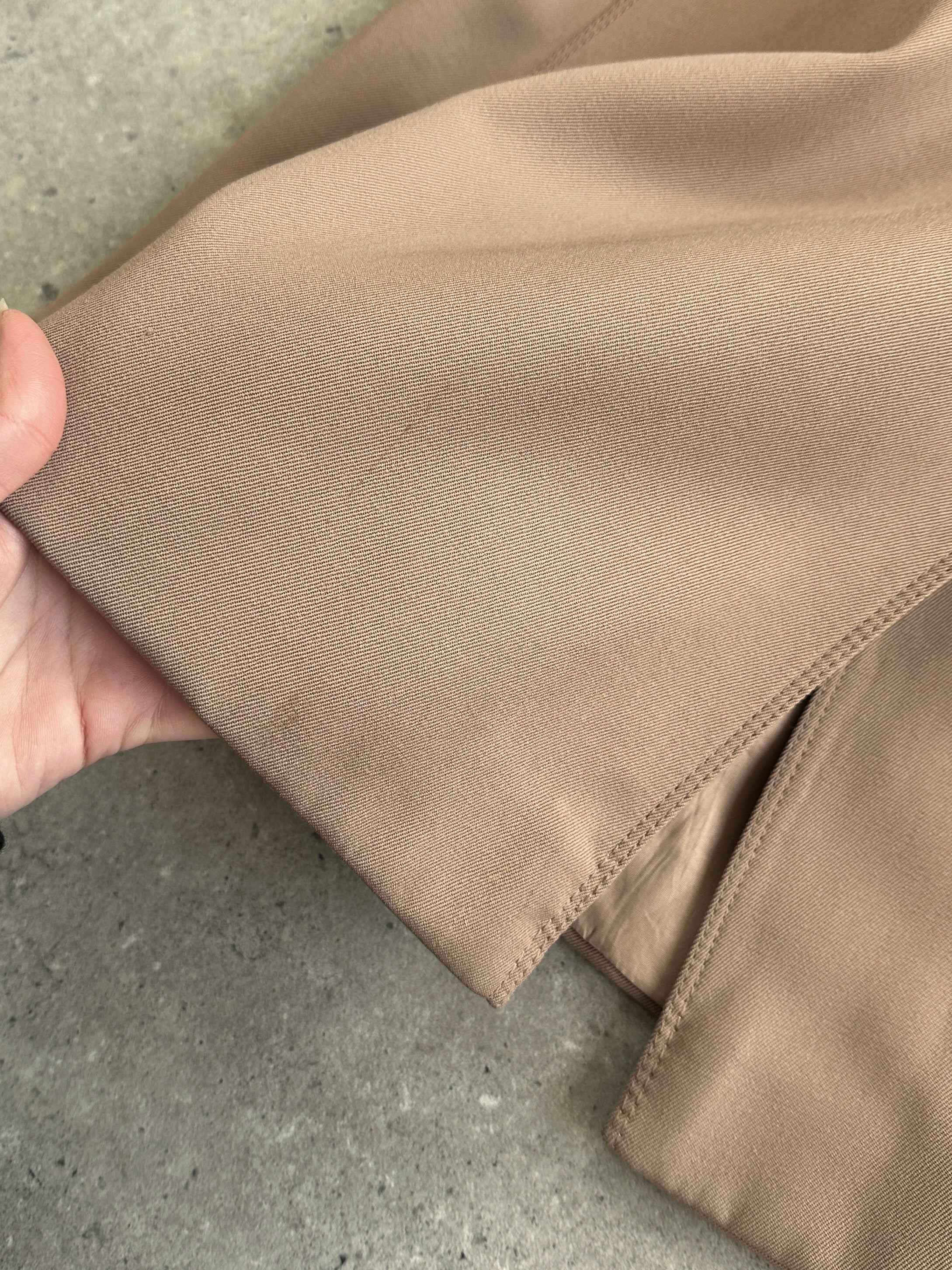 Vintage pure virgin wool double-breasted belted trench coat in classic style, shown hanging on a hanger.