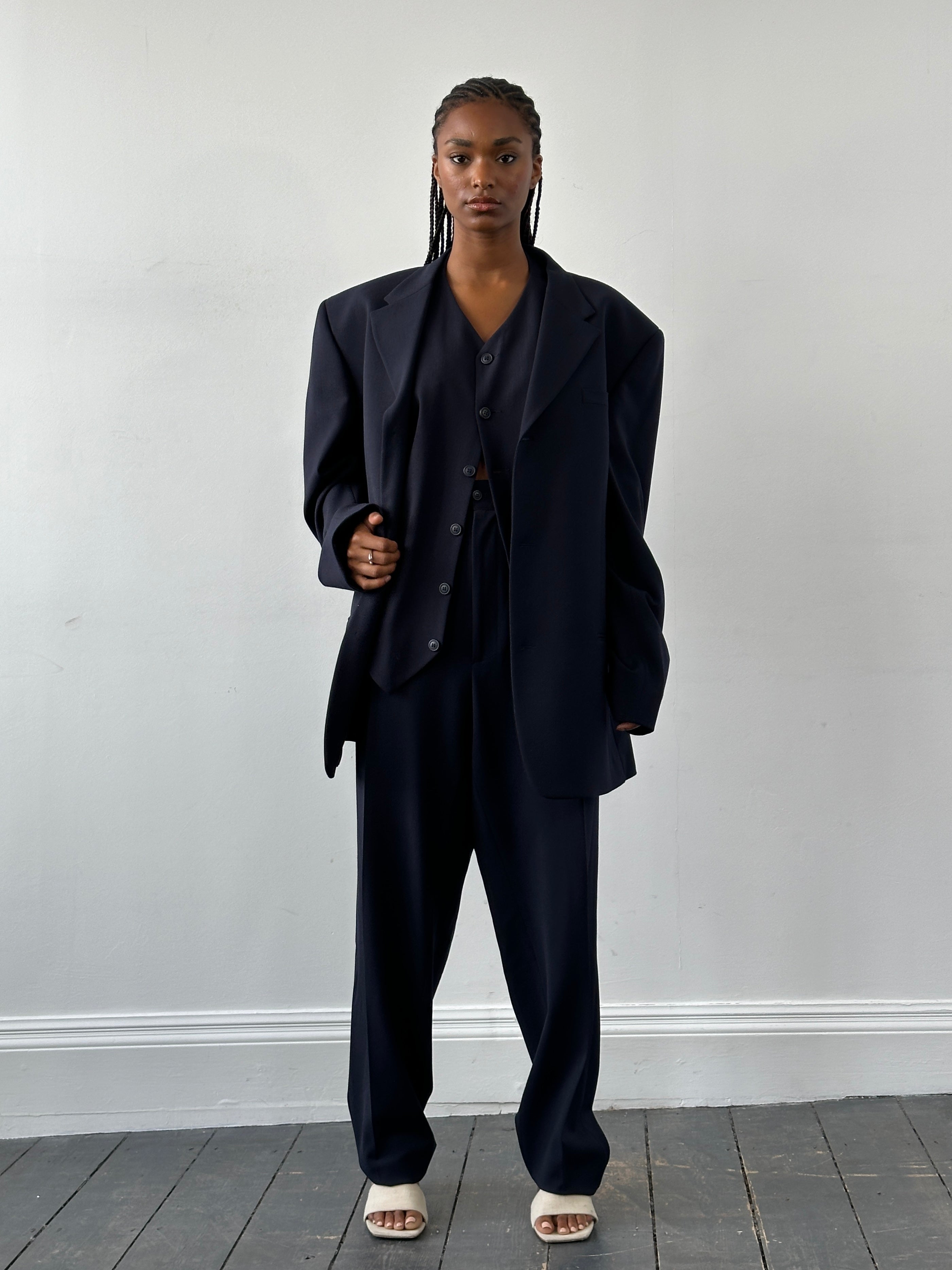 Versace Versus 1990s three-piece suit in size 48R/W32, featuring tailored jacket, vest, and trousers, displayed on a hanger.