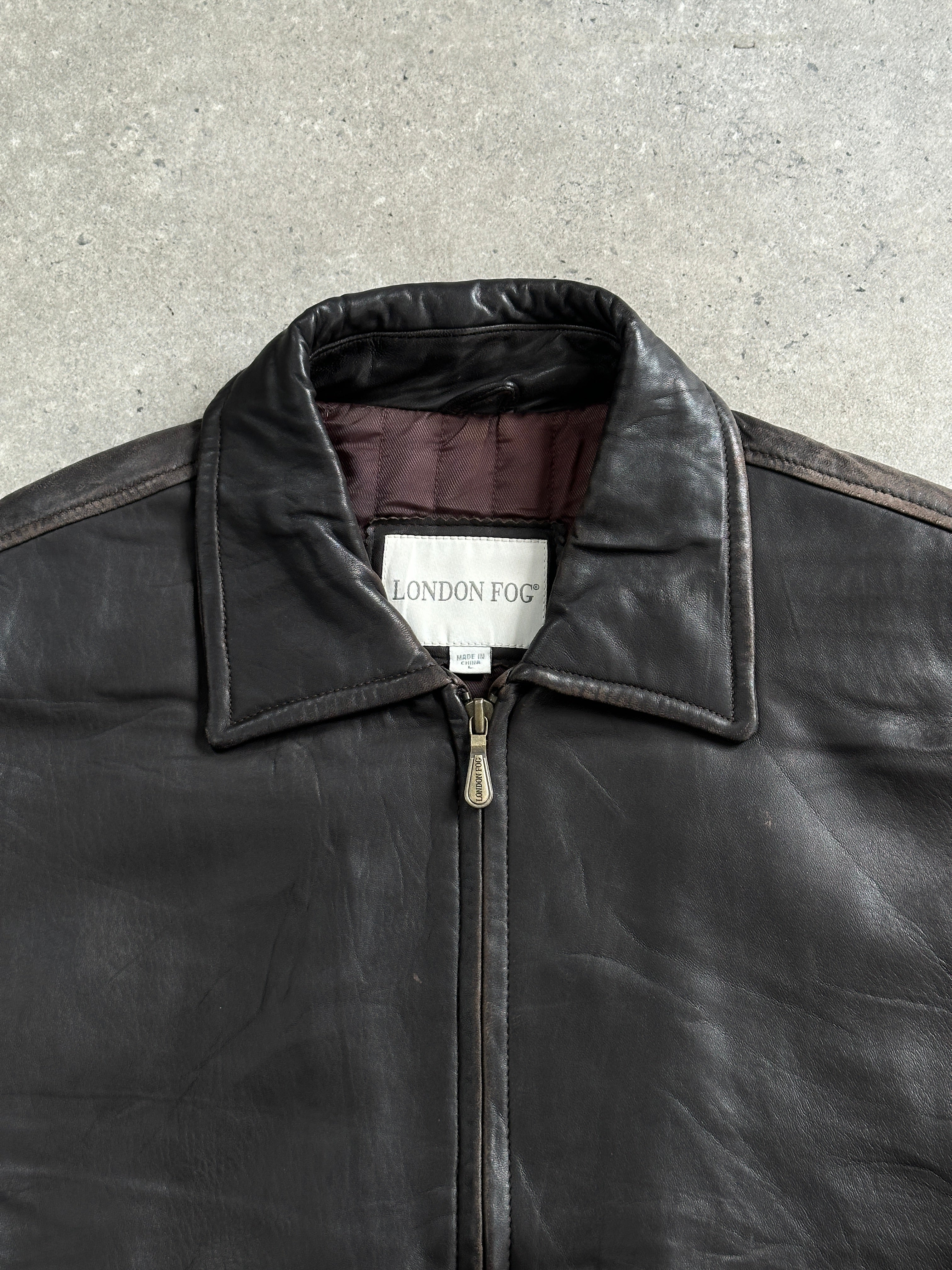 London Fog 1990s distressed leather jacket, size large, showcasing rugged texture and classic design in a close-up shot.