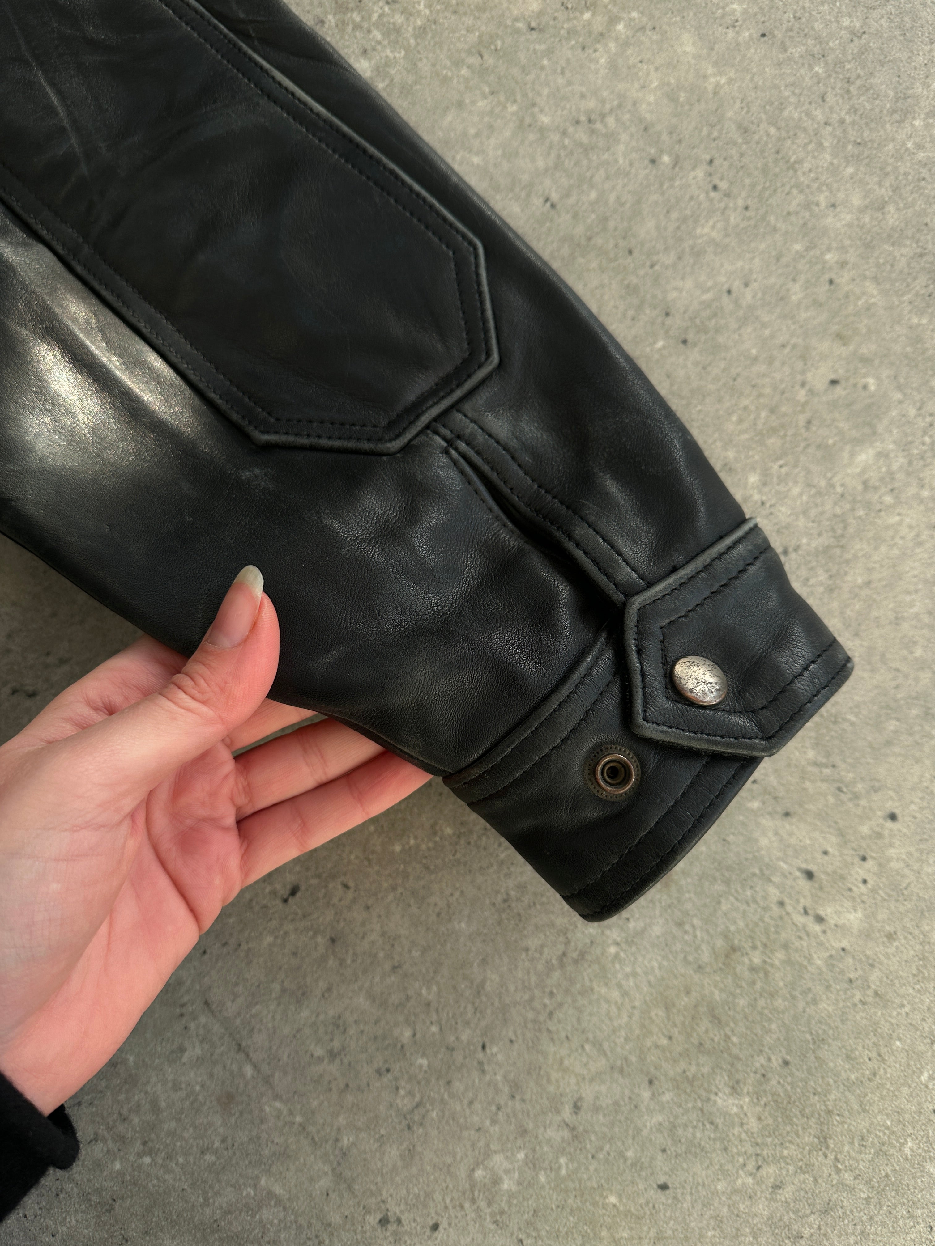 Vintage leather jacket in size XL, showcasing classic design with visible stitching and a rugged leather texture.