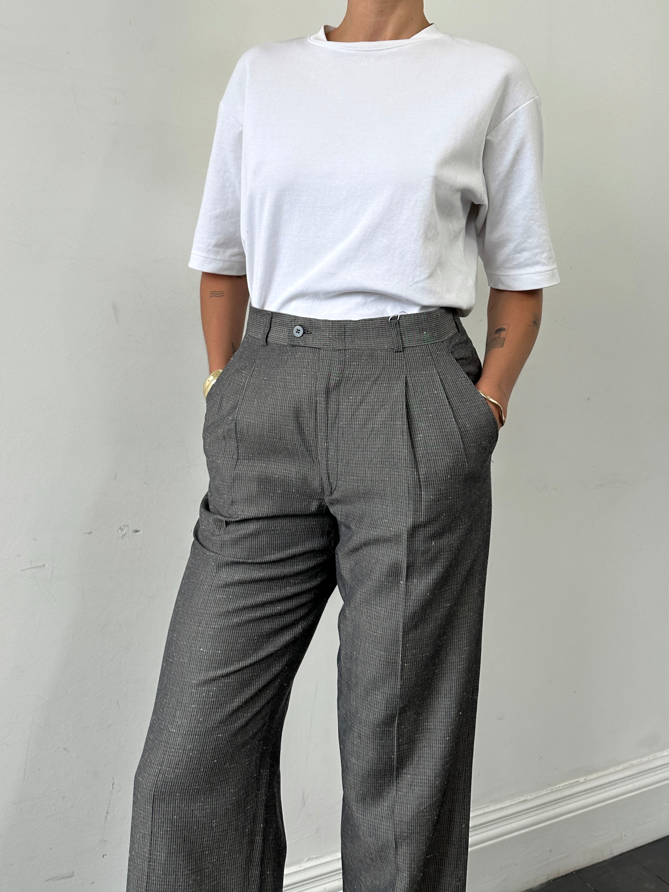 Vintage Italian high waisted tailored trousers with straight leg fit, raw hem, in size W28, showcasing classic vintage style.