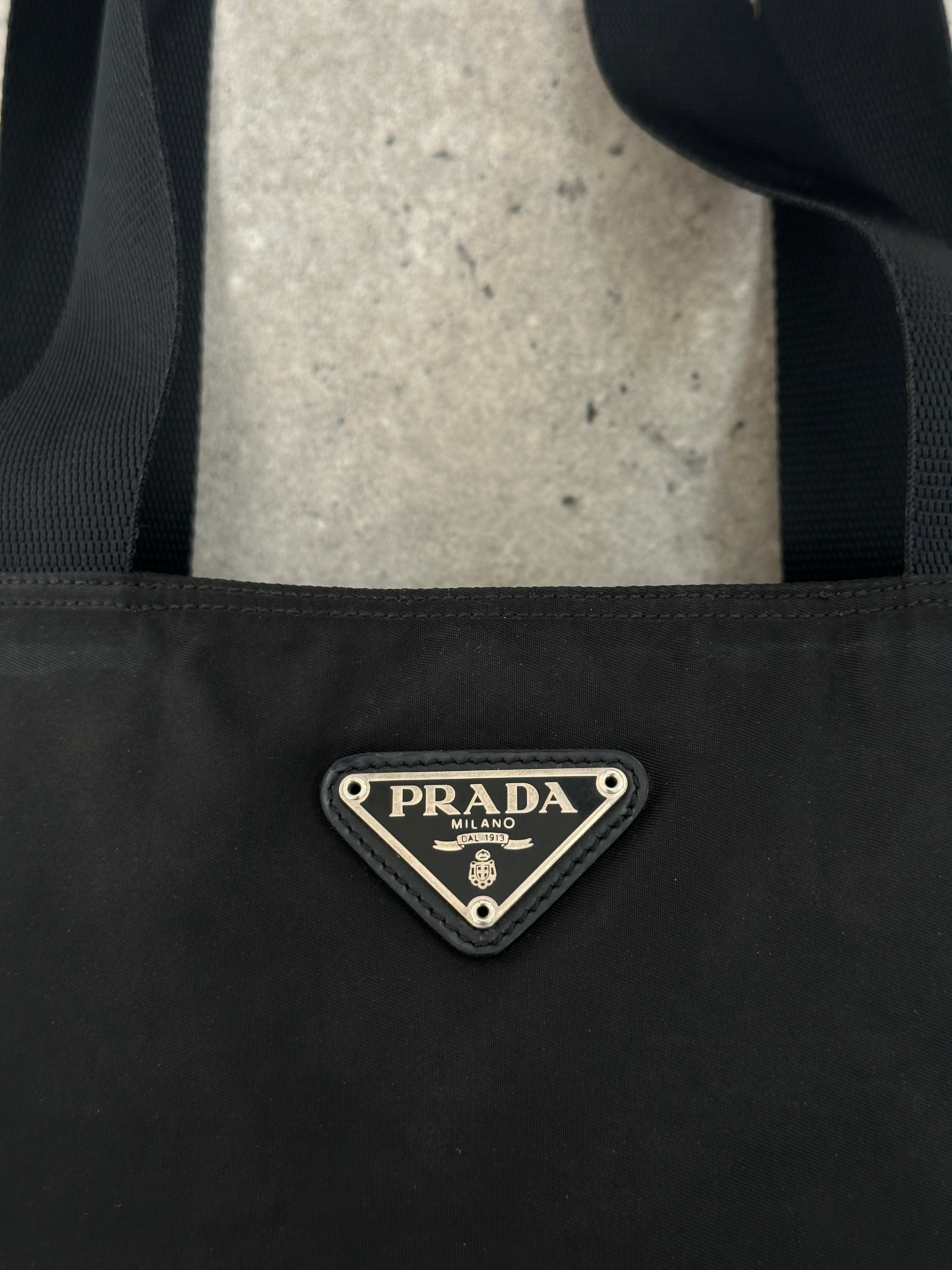 Prada 1997 nylon shoulder bag with adjustable strap, featuring sleek design and signature Prada branding on the exterior.