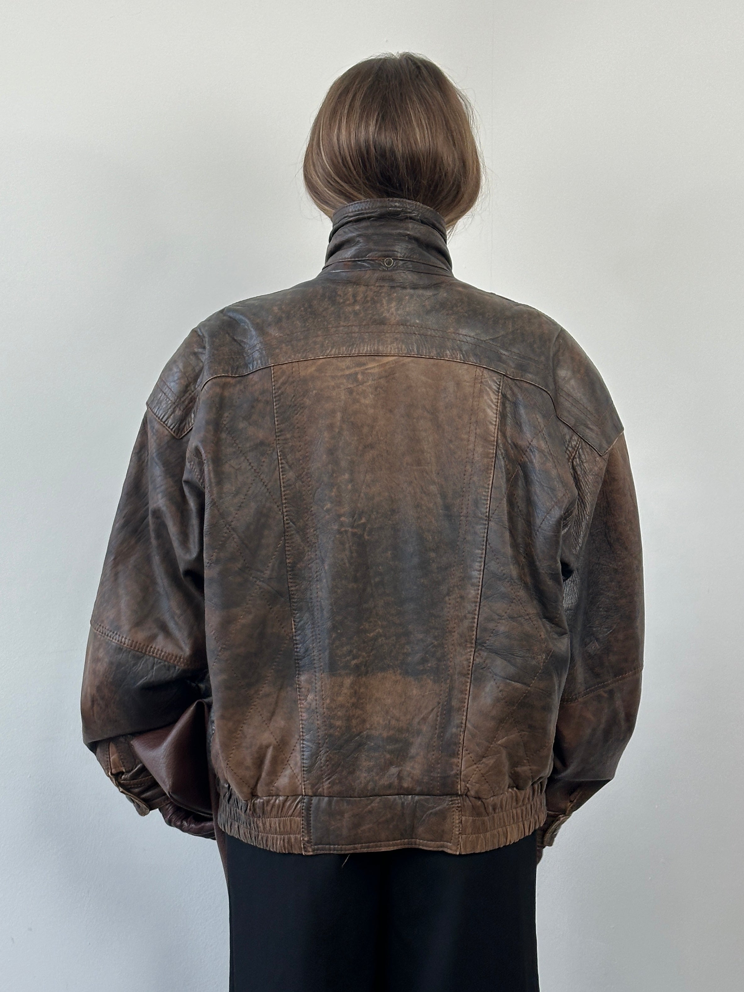 Vintage 1990s high neck leather bomber jacket in aged leather, oversized fit, classic vintage style, front view.