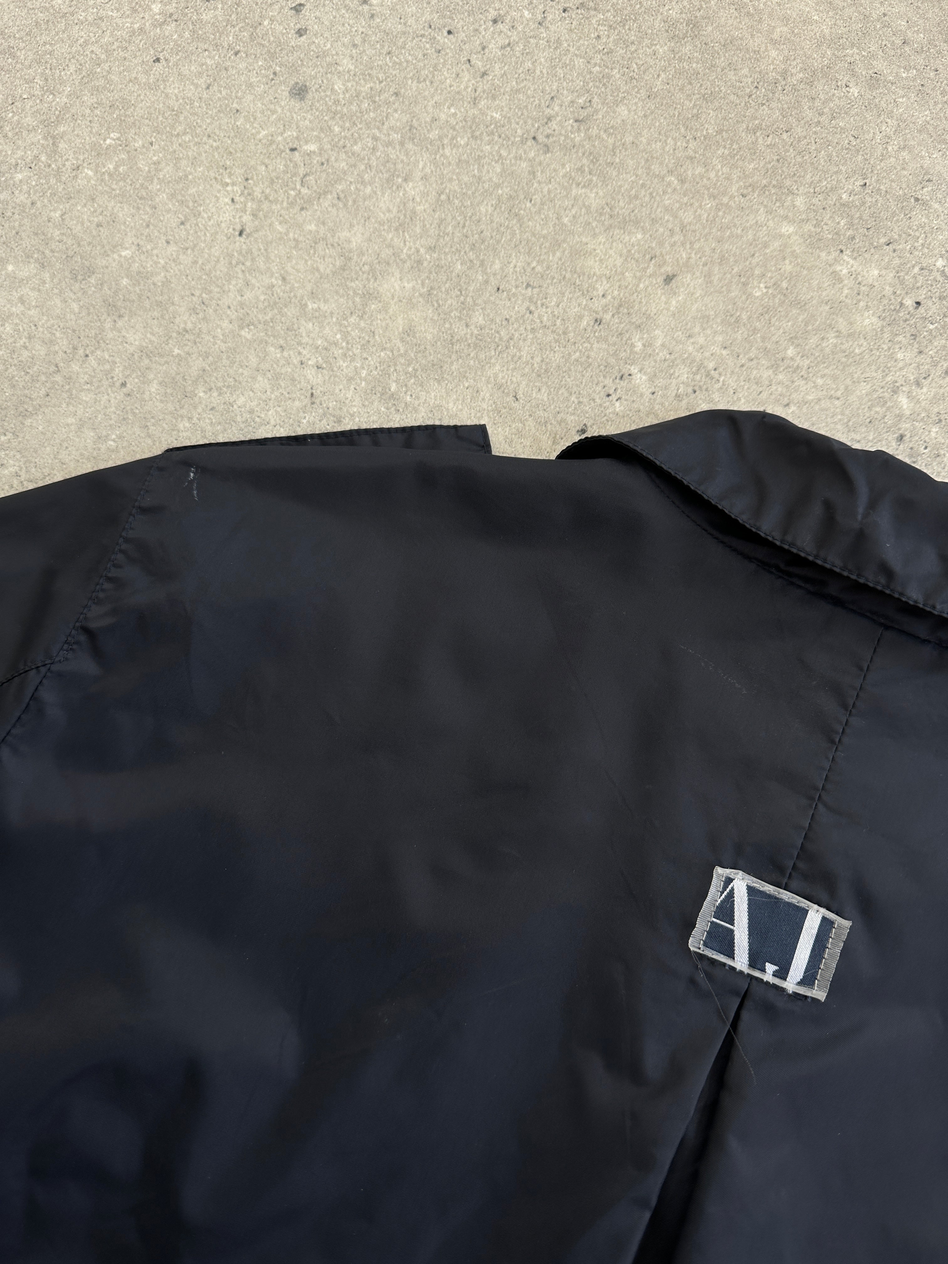 Armani Jeans 1990s showerproof nylon lightweight logo jacket in size S/M, with a sleek design and Armani branding.