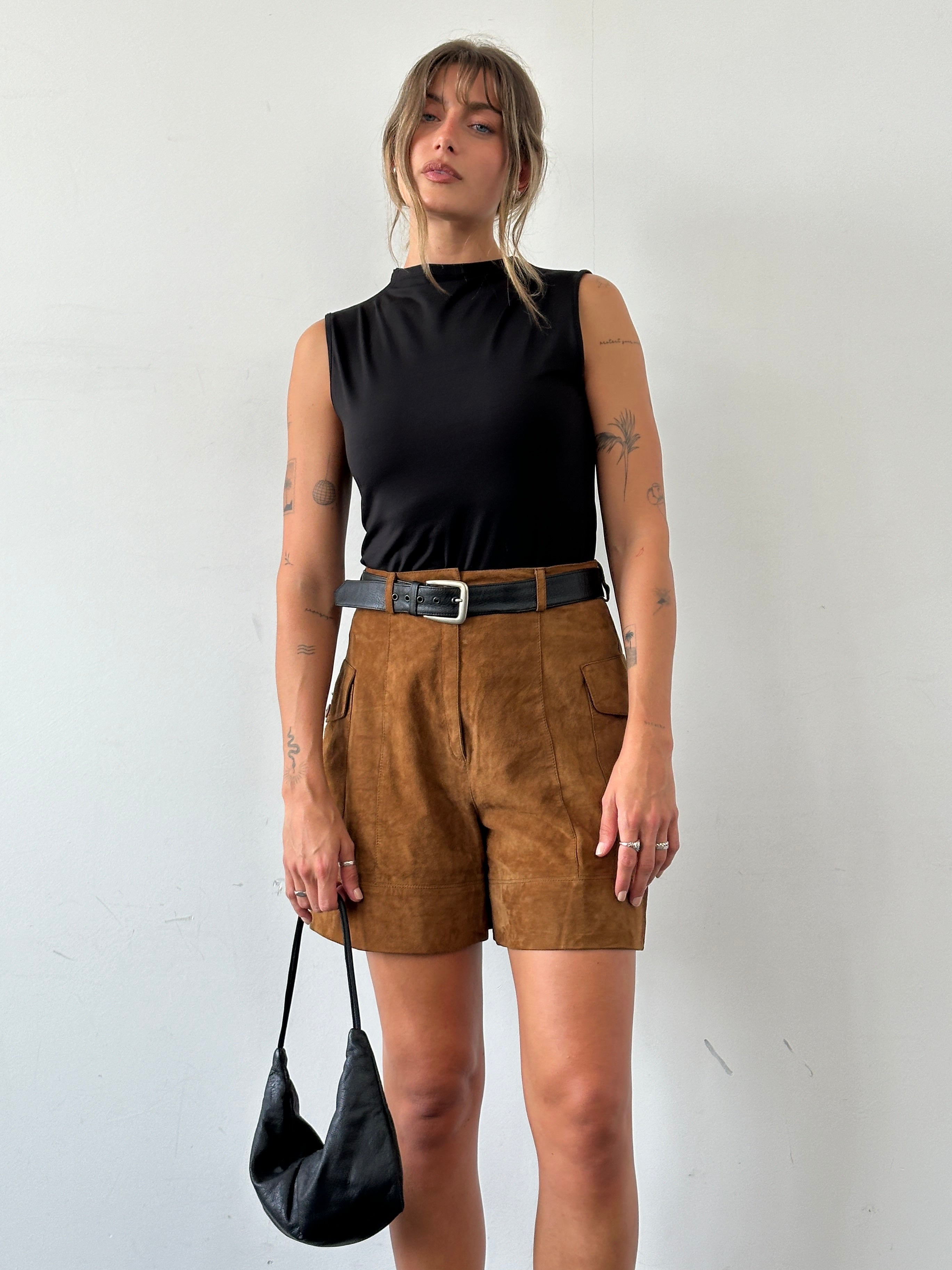 Vintage Italian high waisted suede leather shorts with a classic fit, shown in a natural beige color, size W27.
