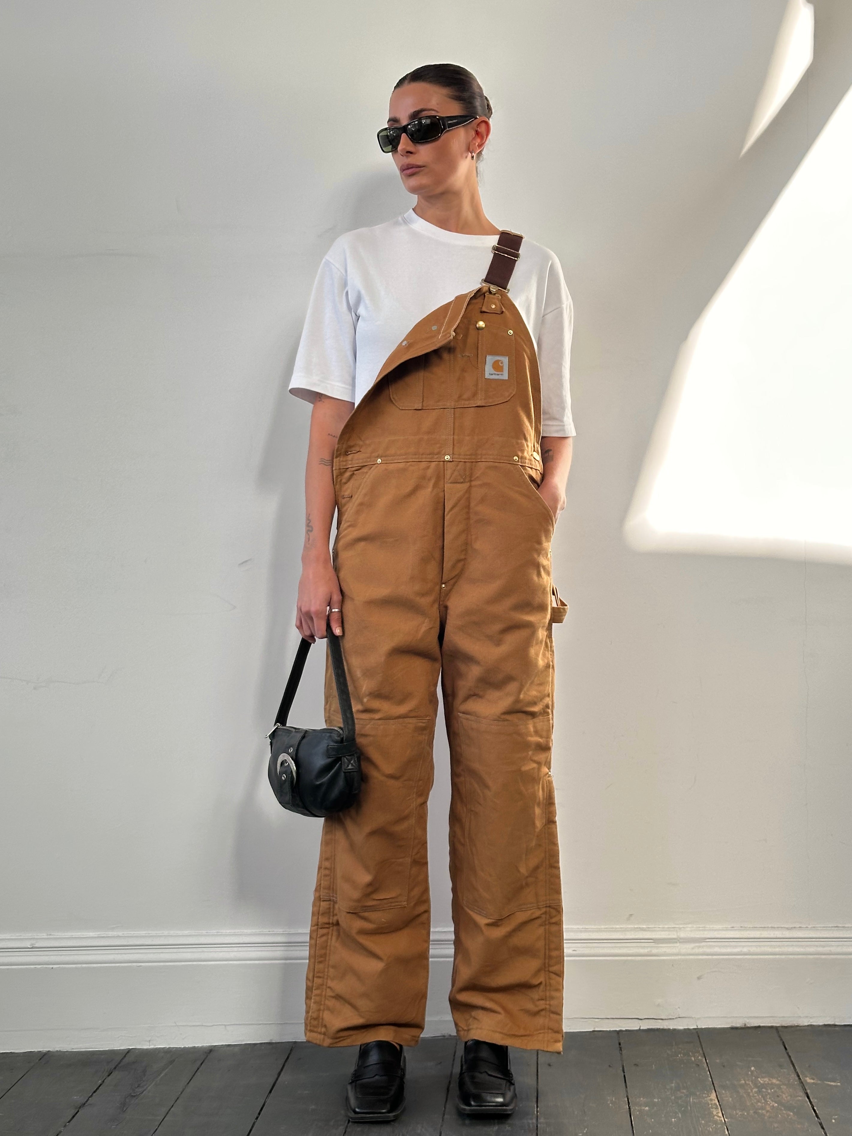 Carhartt pure cotton dungarees in size M, featuring durable fabric and classic workwear design, displayed on a flat surface.