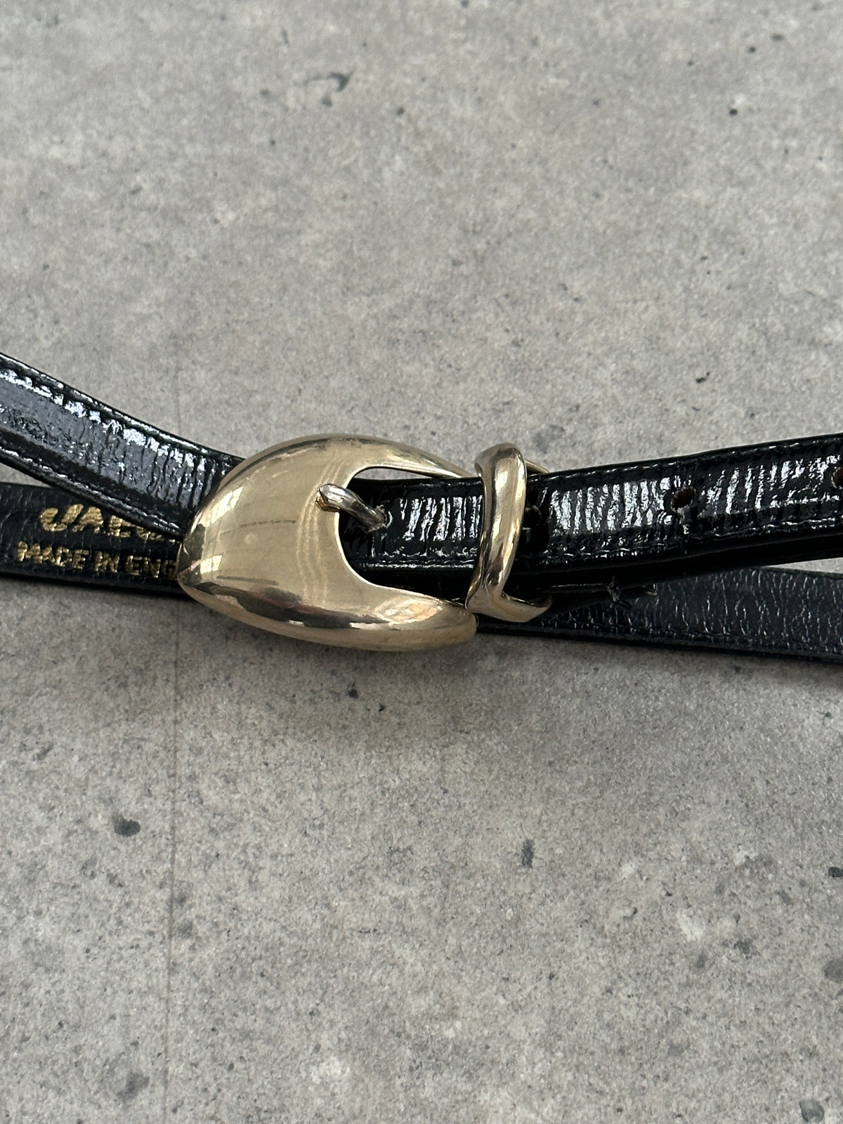 Jaeger 1990s patent leather sculptural buckle belt with bold buckle design, W30-35, stylish vintage accessory for fashion-forward outfits.