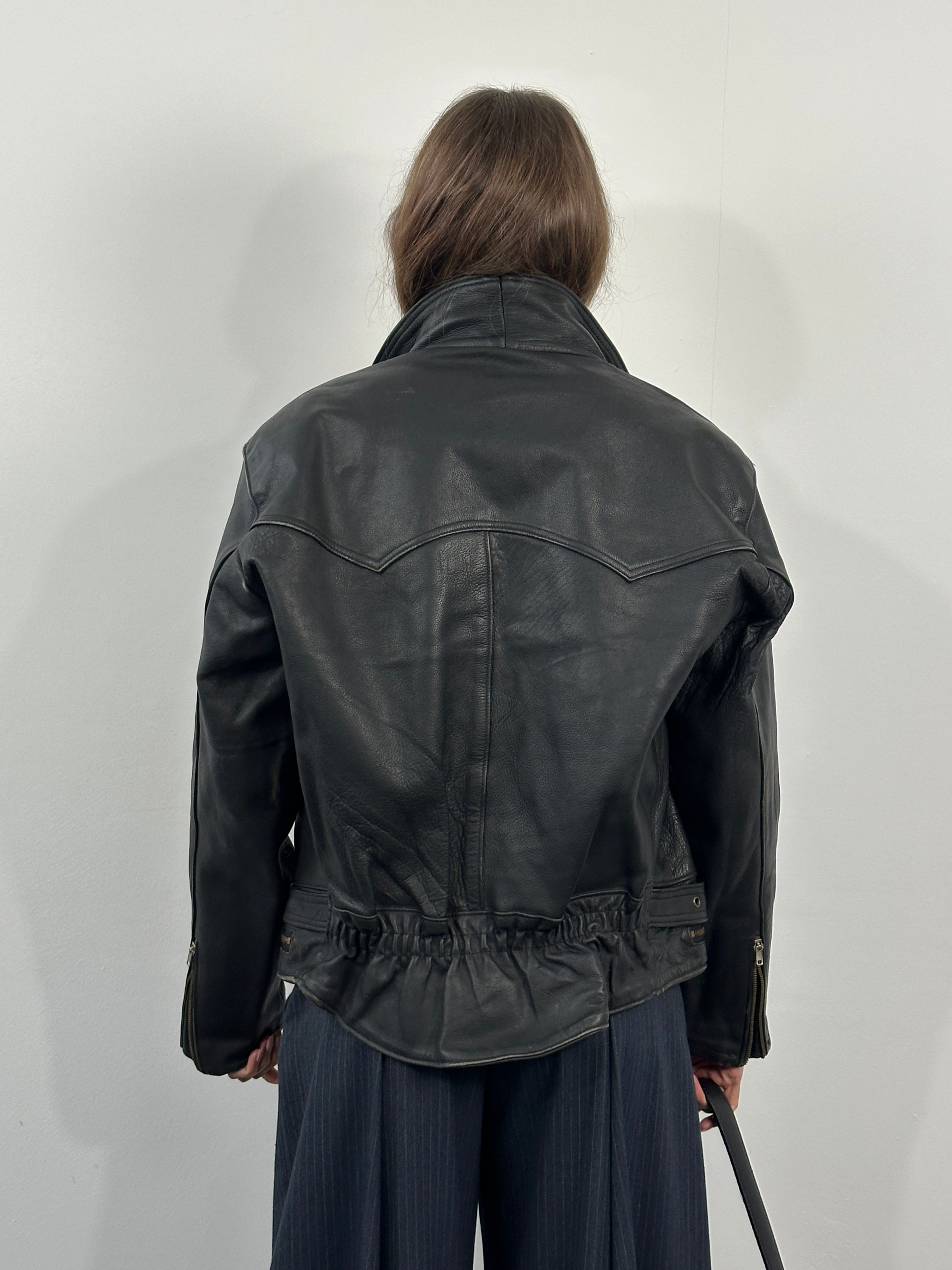 Vintage 1990s leather biker jacket with classic design, black leather, and metal hardware, size M/L.