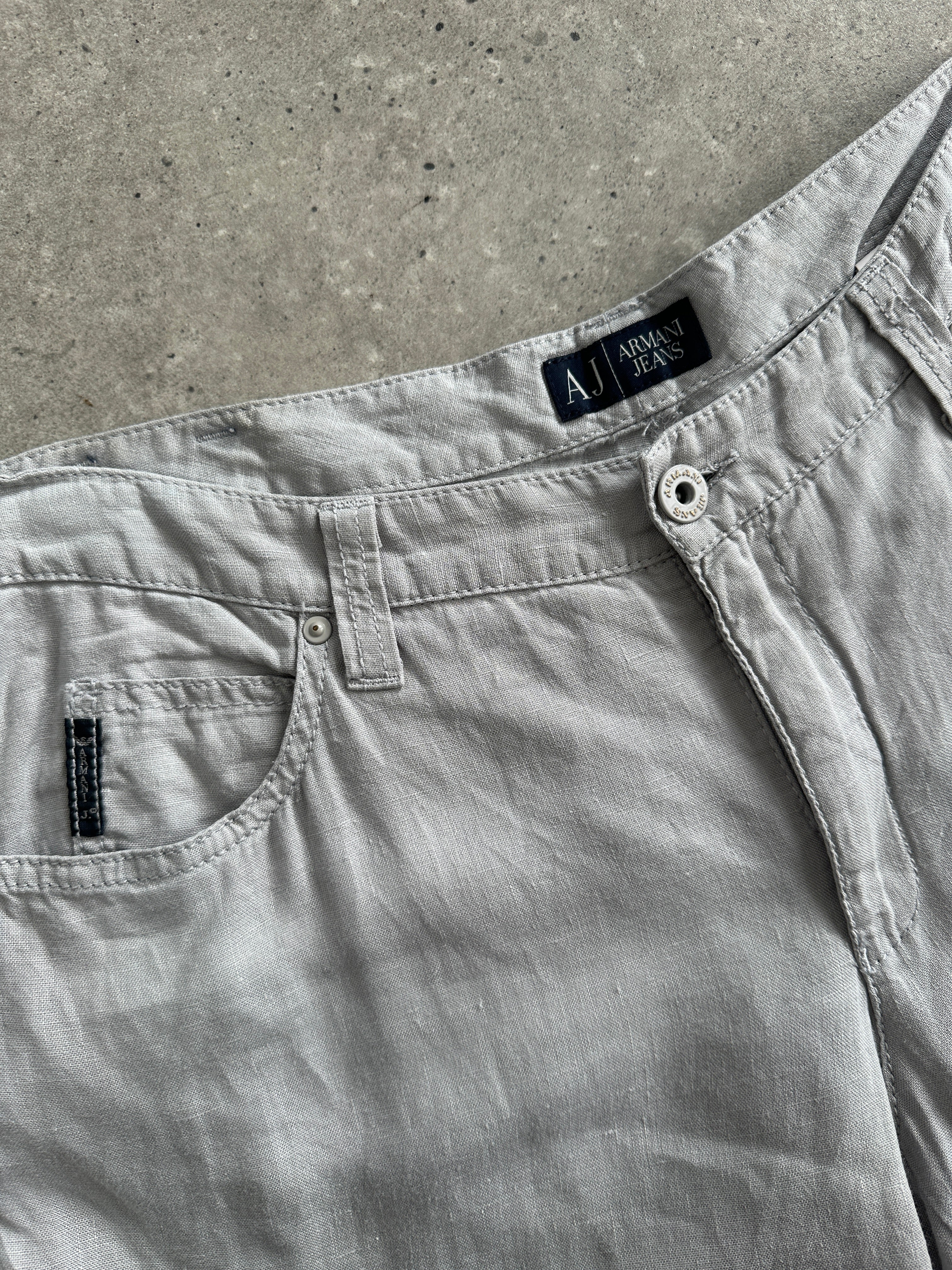 Armani Jeans pure linen flared trousers in size W33, shown laid flat with waistband and flared leg openings.