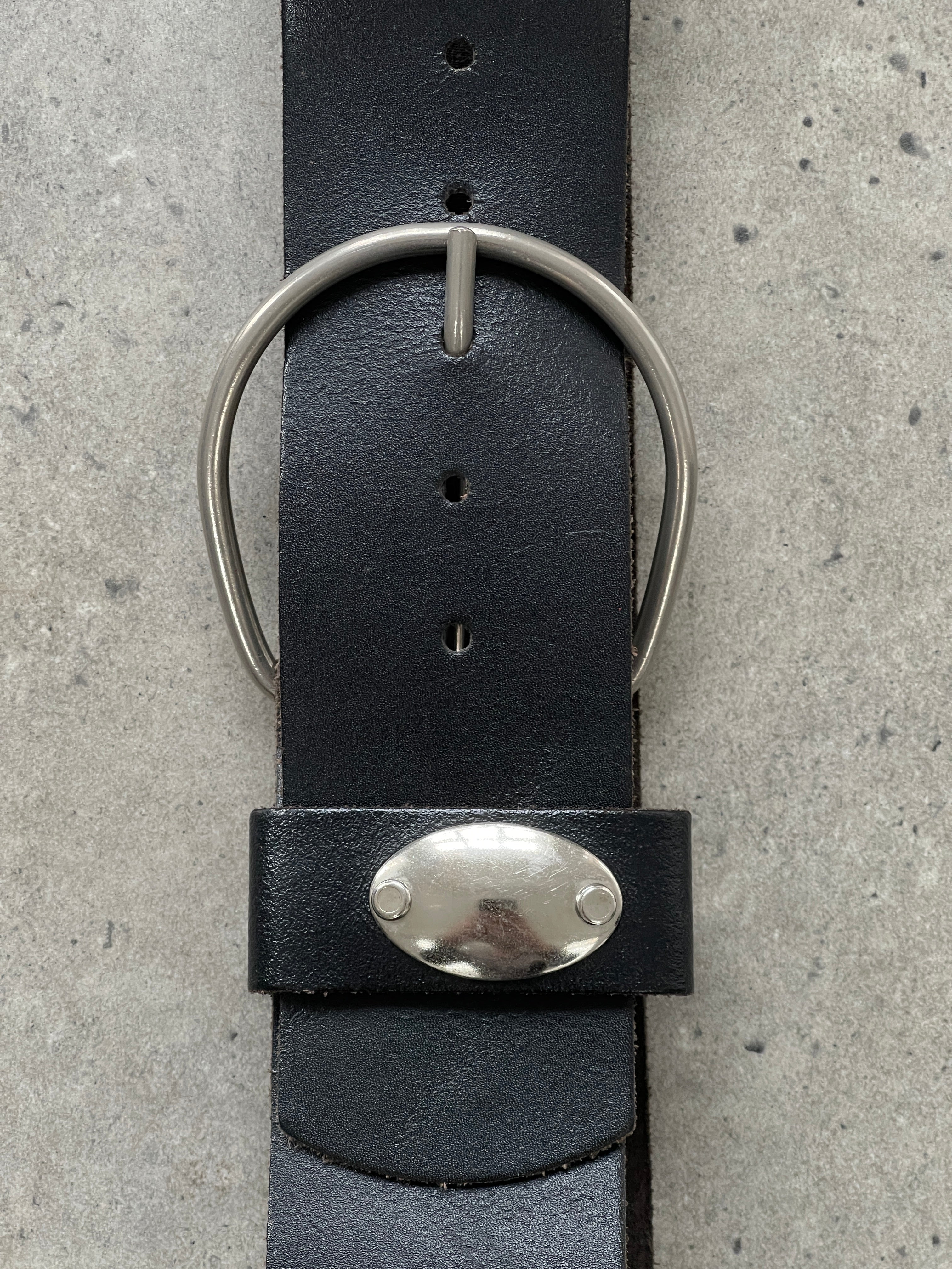 Vintage 1990s chunky leather belt with adjustable W28-32 shown laid flat, featuring a classic buckle and distressed leather finish.