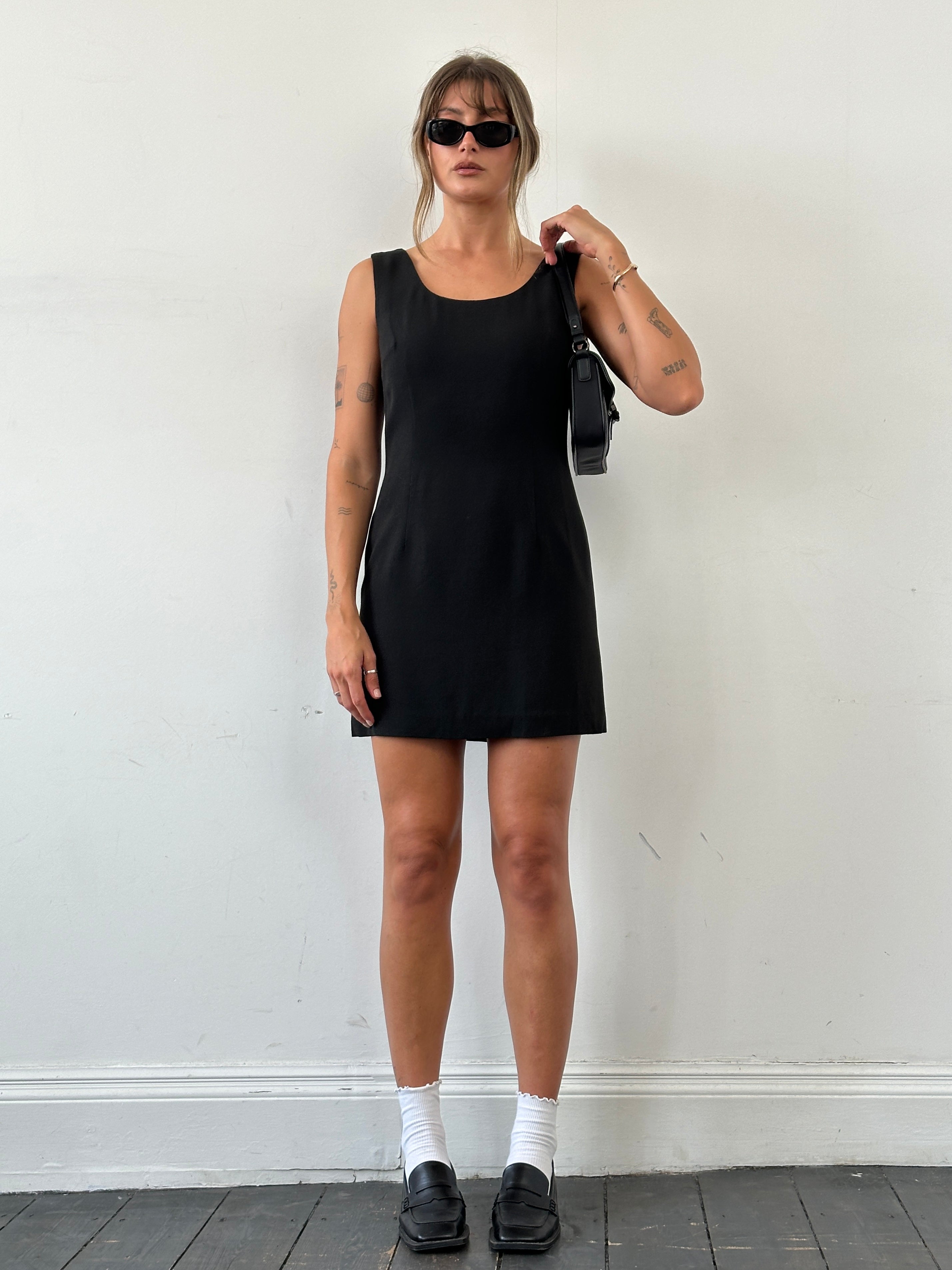 Dolce & Gabbana fitted mini dress in black, showcasing a sleek silhouette and elegant design with short sleeves and a stylish neckline.