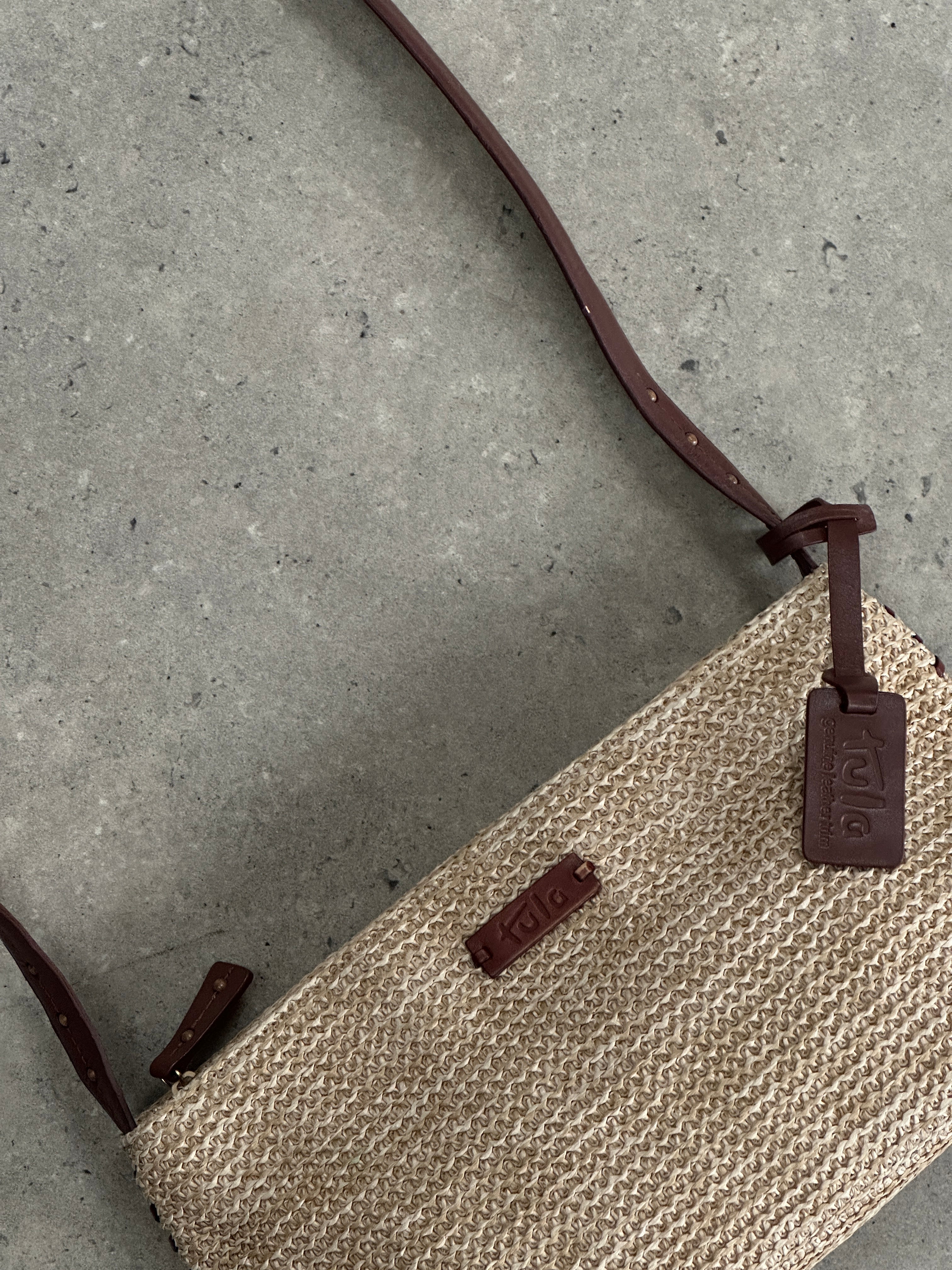 Vintage raffia crossbody bag with woven texture, featuring a compact design and adjustable strap for casual style.