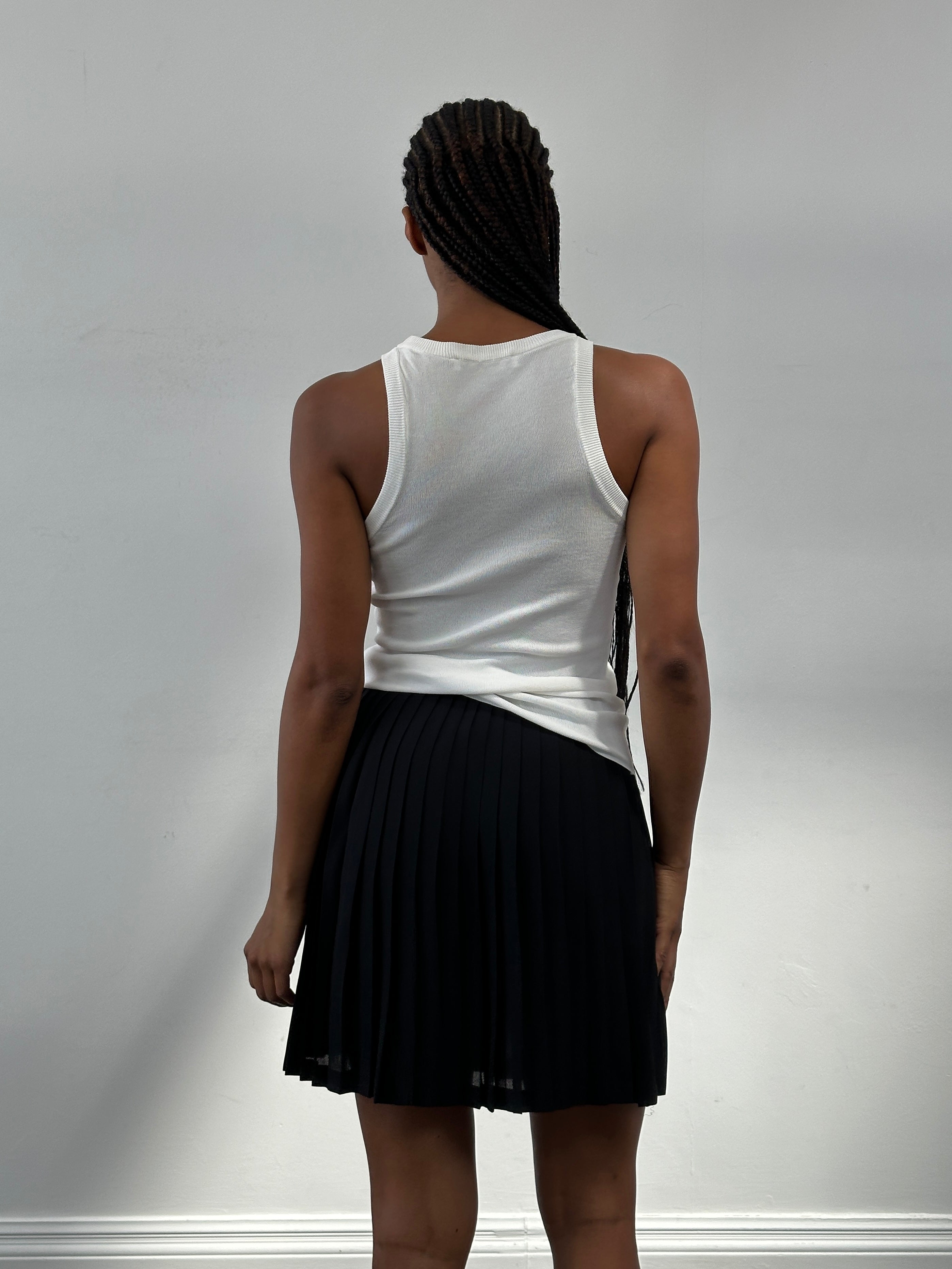 Vintage Italian 1990s pleated A-line mini skirt in W26, featuring classic design and lightweight fabric.