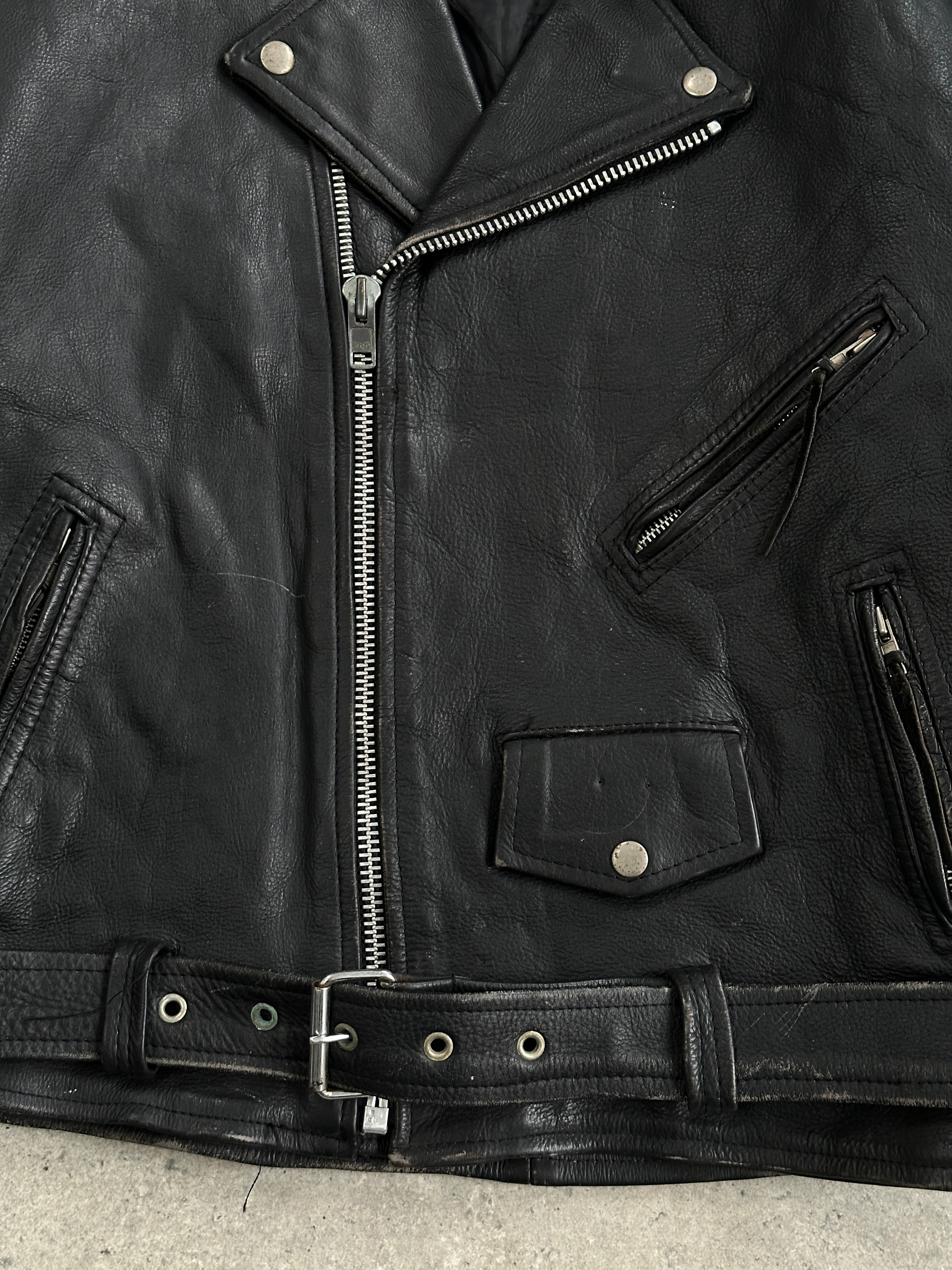 Vintage leather biker jacket in XL size, featuring classic styling, rugged texture, and detailed stitching.