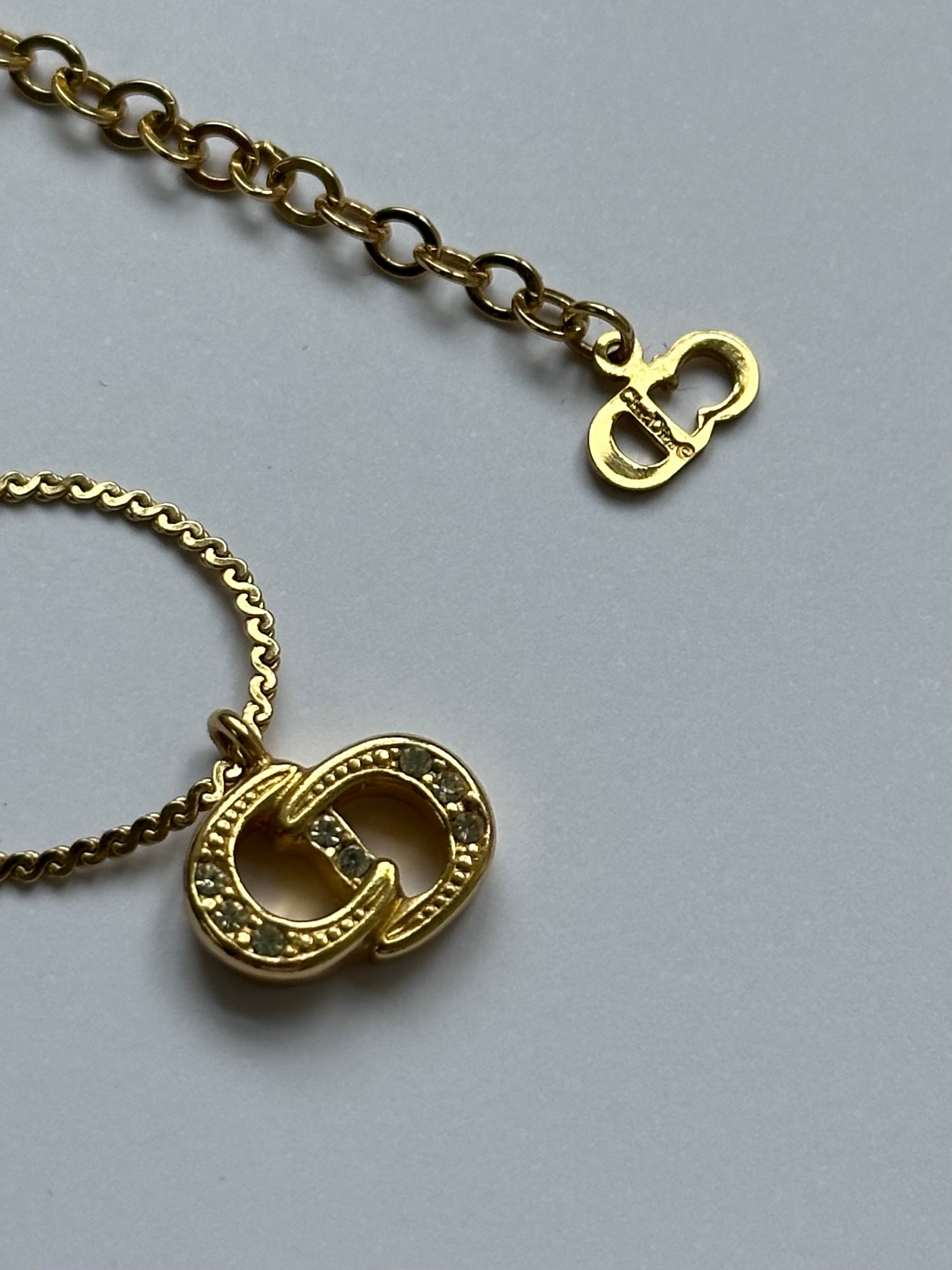Christian Dior 16-inch gold plated rhinestone logo pendant necklace showing the sparkling Dior logo and chain detail.