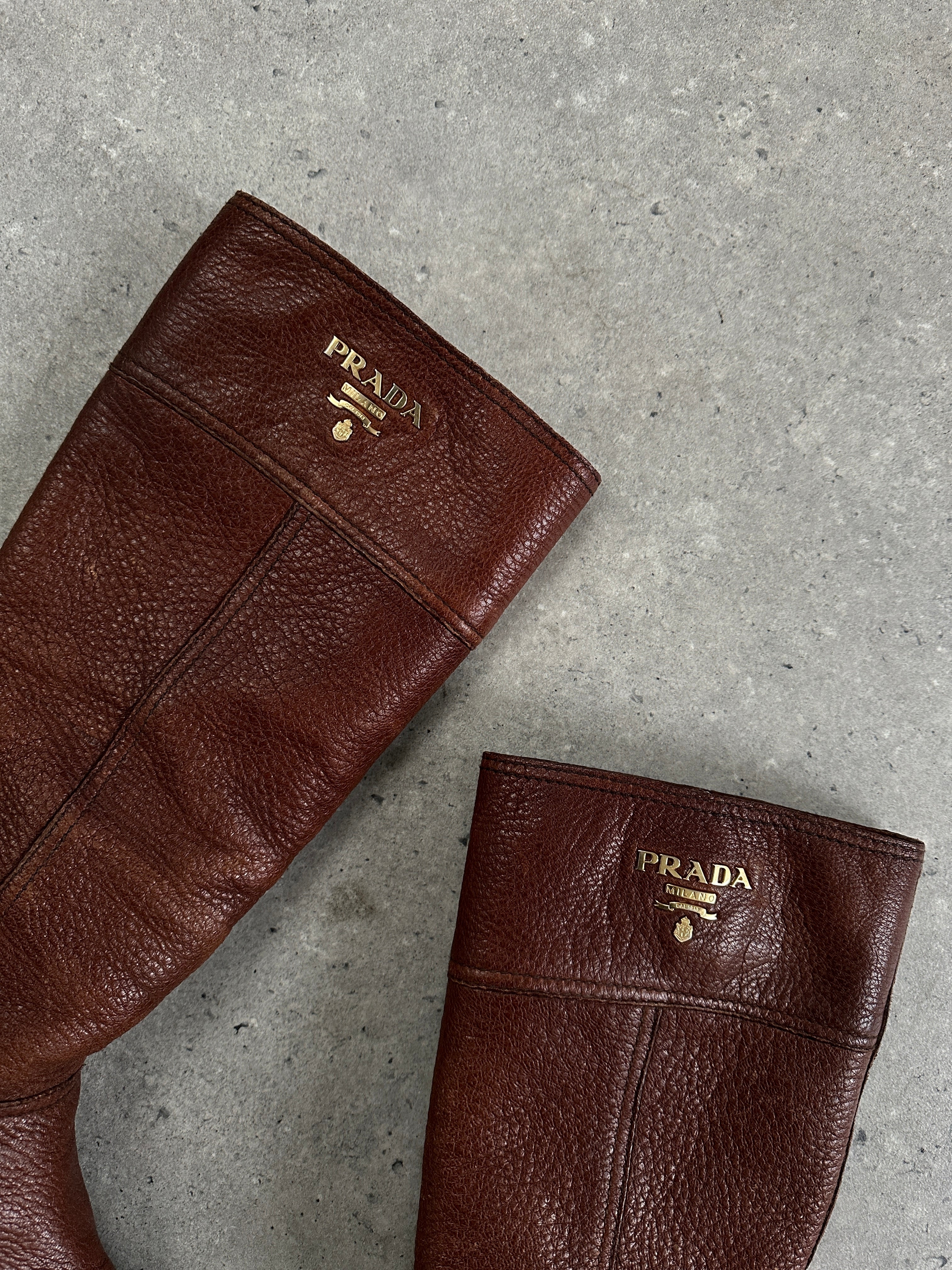 Prada leather logo knee boots in black, UK size 4, featuring sleek design and knee-high silhouette with Prada branding.