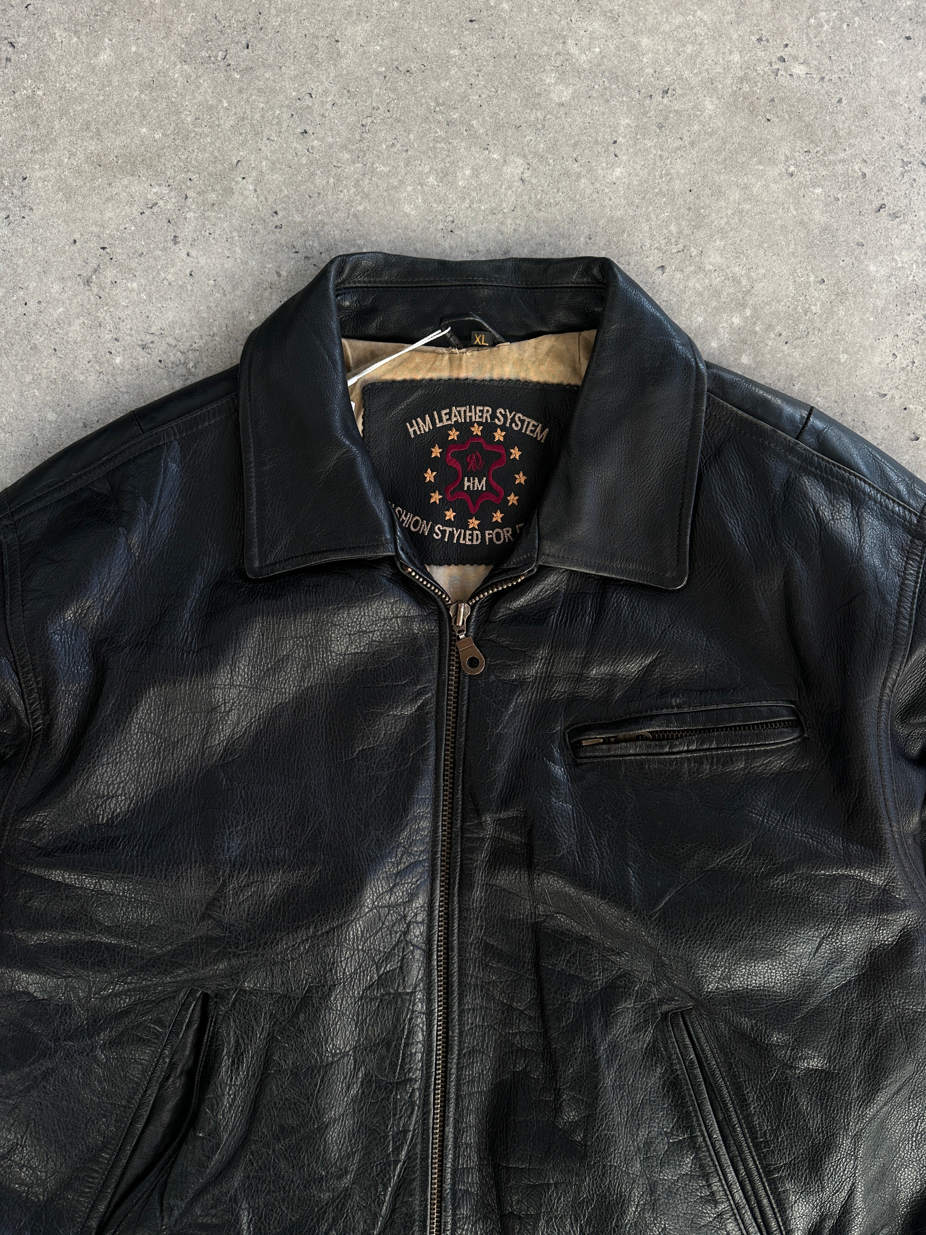Vintage leather jacket in size XL, featuring classic design and durable leather material, displayed on a hanger.