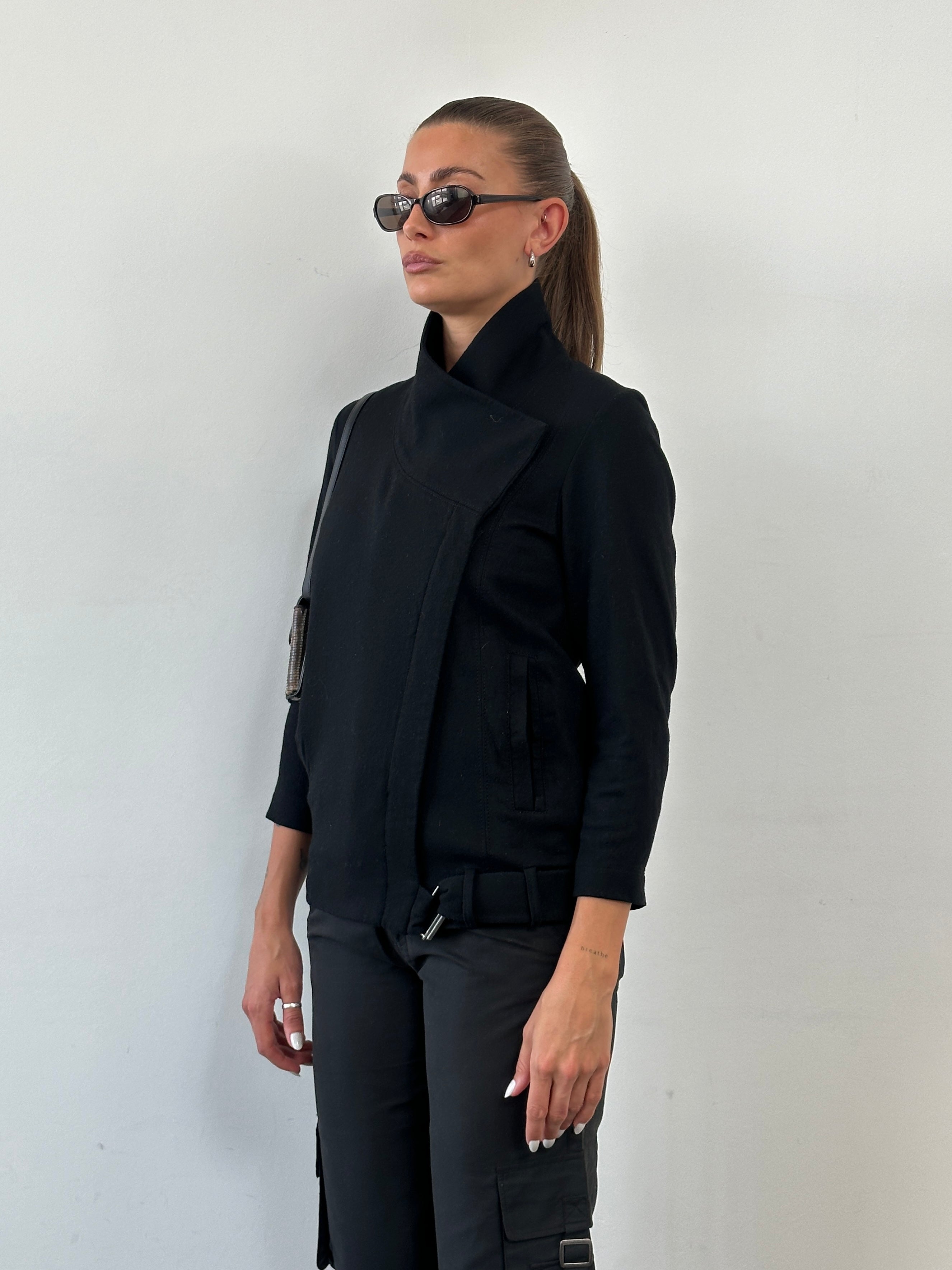 Helmut Lang asymmetric high neck wool belted jacket in black, featuring a tailored fit and stylish design, displayed on a hanger.