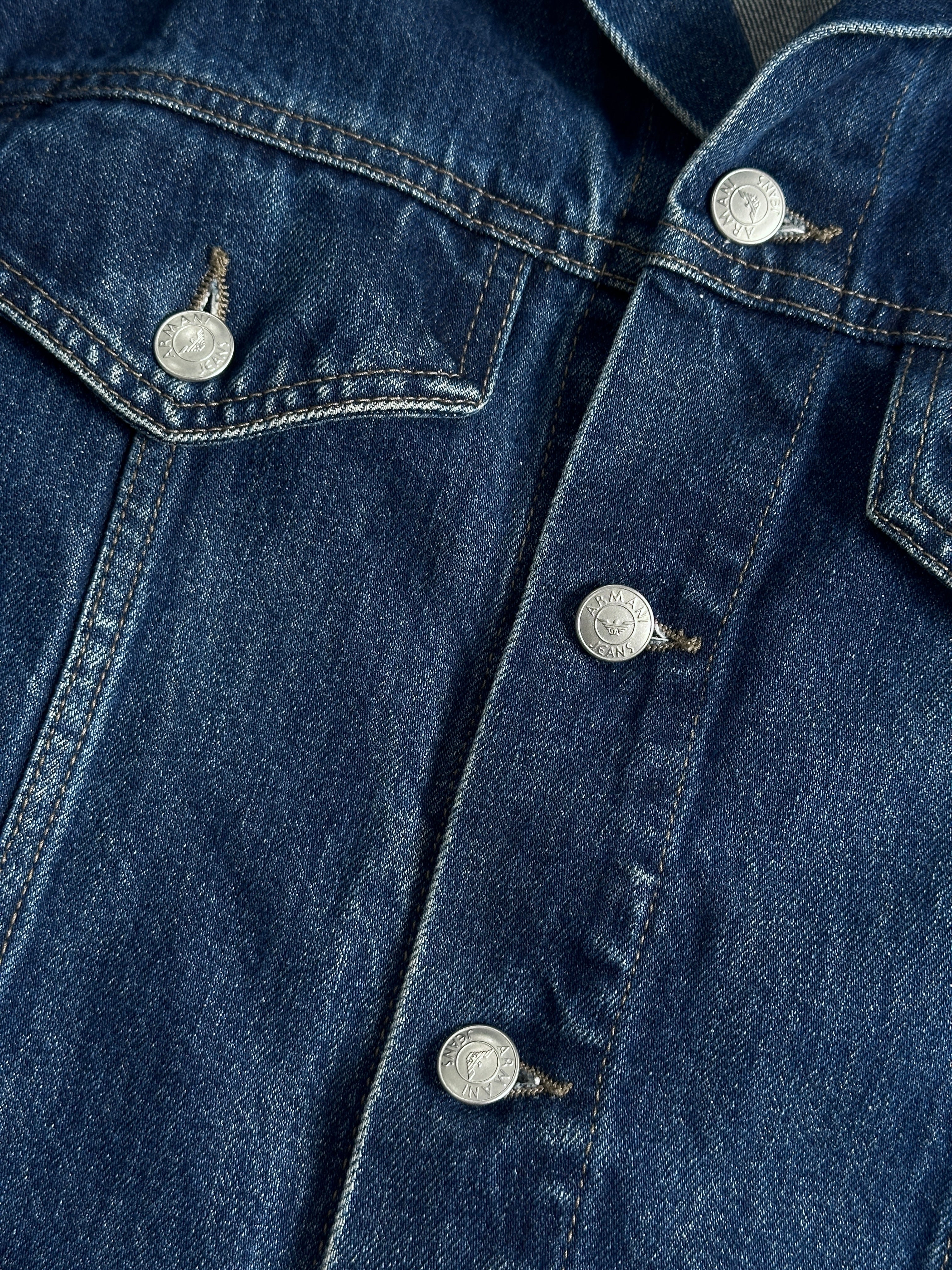 Armani Jeans mid wash denim jacket in size S/M, featuring classic styling and visible stitching on a casual model.