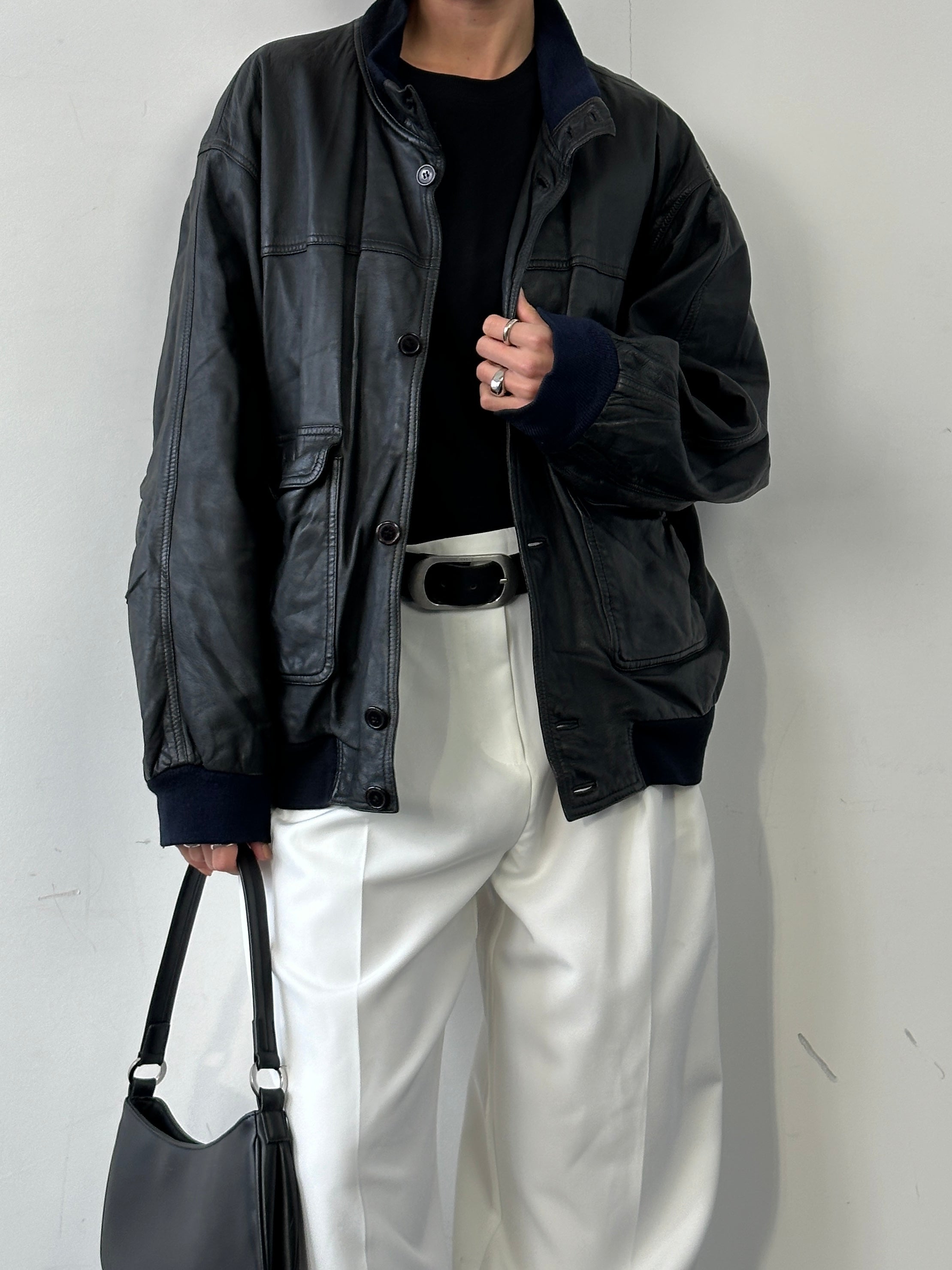 Vintage leather bomber jacket in size L/XL, featuring classic design with ribbed cuffs and collar, worn by a model.