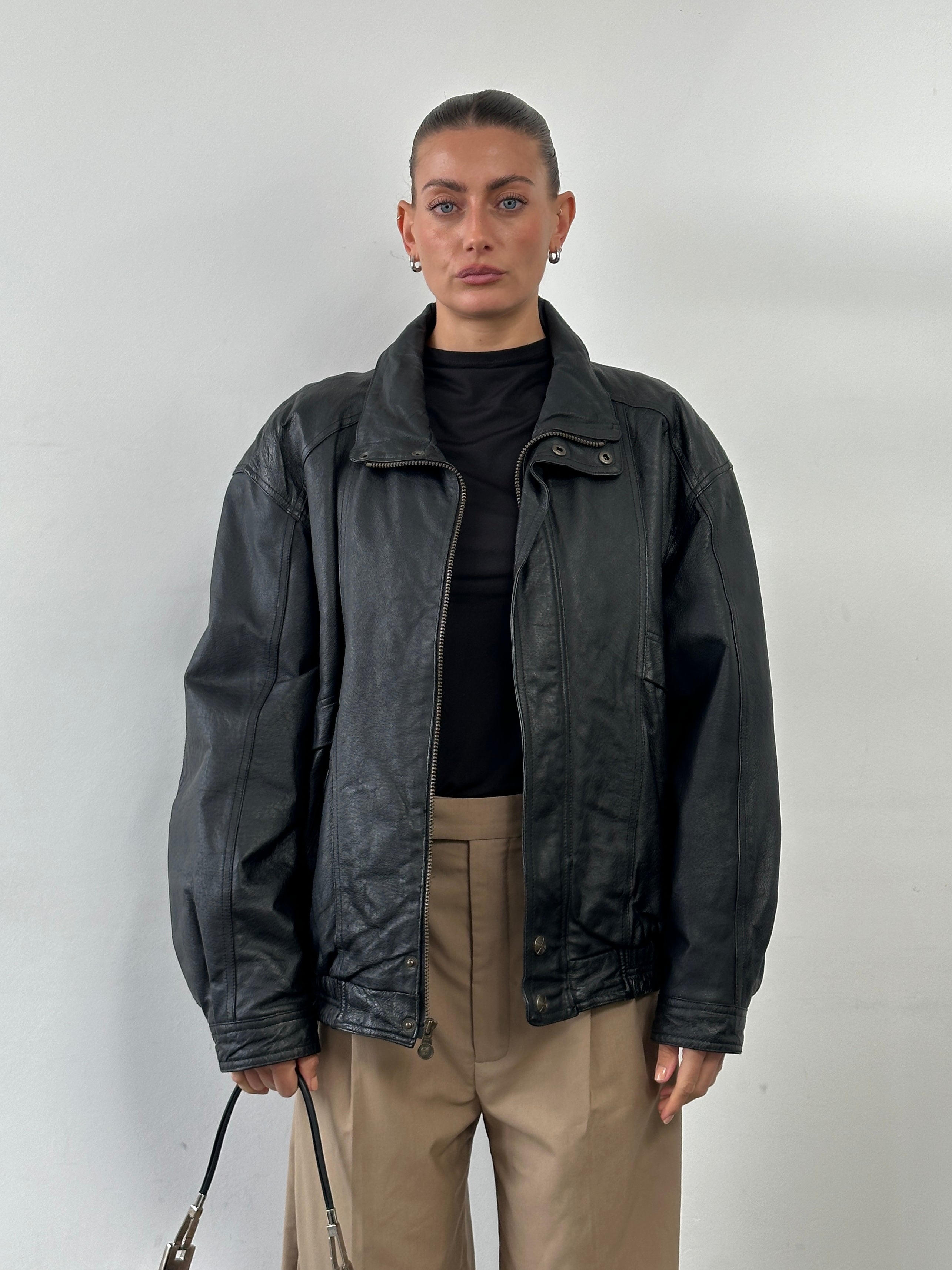 Vintage high neck leather bomber jacket in XL, featuring classic design with a smooth leather finish and ribbed collar and cuffs.