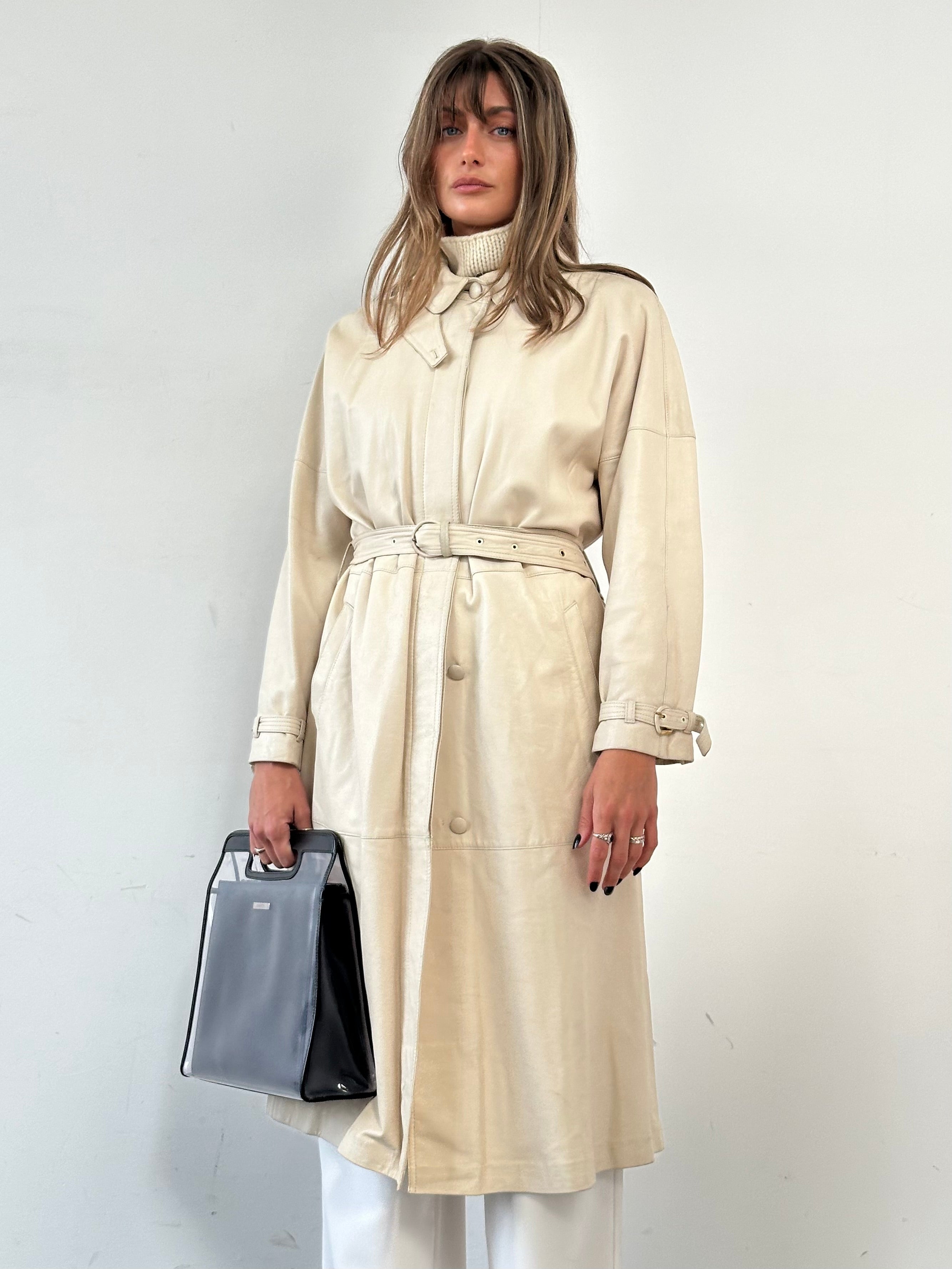 Vintage leather trench coat with belt, long sleeve, classic design, in a vintage style, shown in a front view.