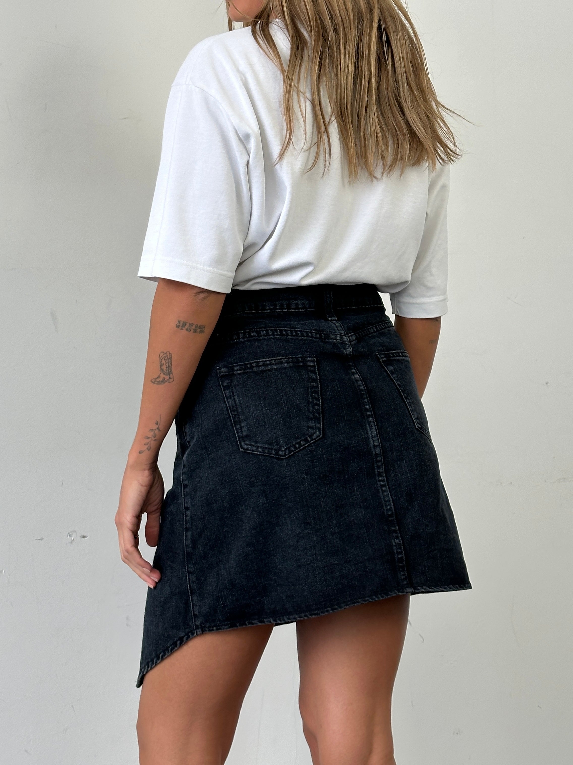Vintage asymmetrical denim mini skirt in classic blue, featuring unique hemlines and fitted waist for a stylish look.