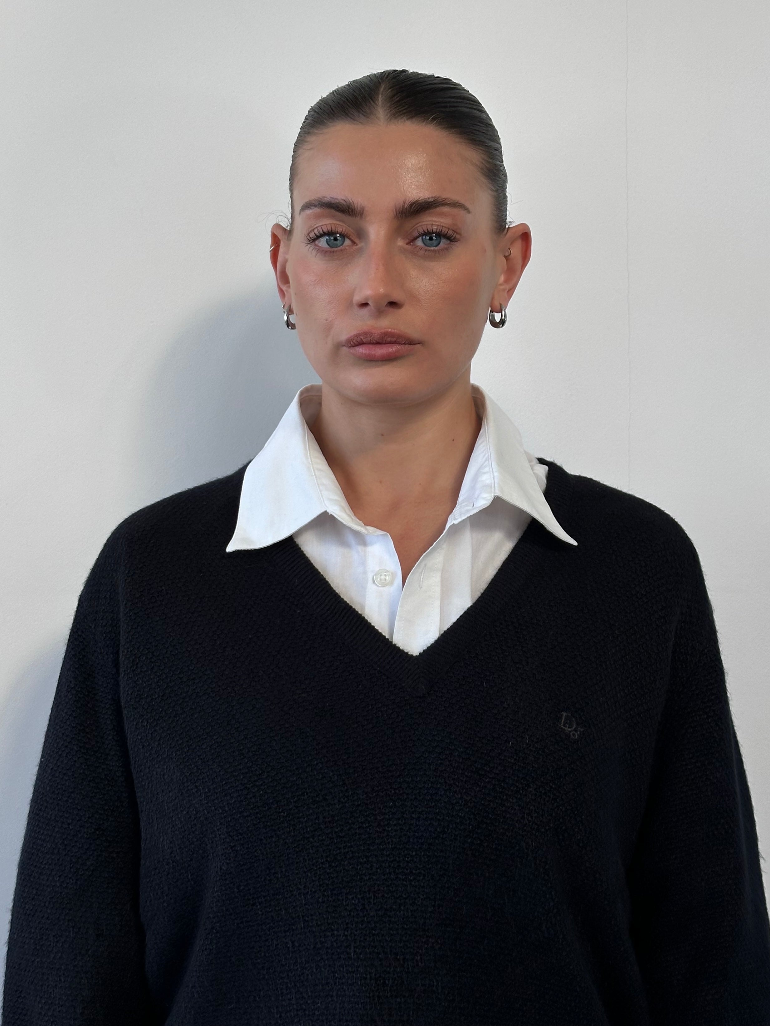 Christian Dior V neck logo knitted jumper in black, featuring a subtle Dior logo and ribbed cuffs, size M/L.