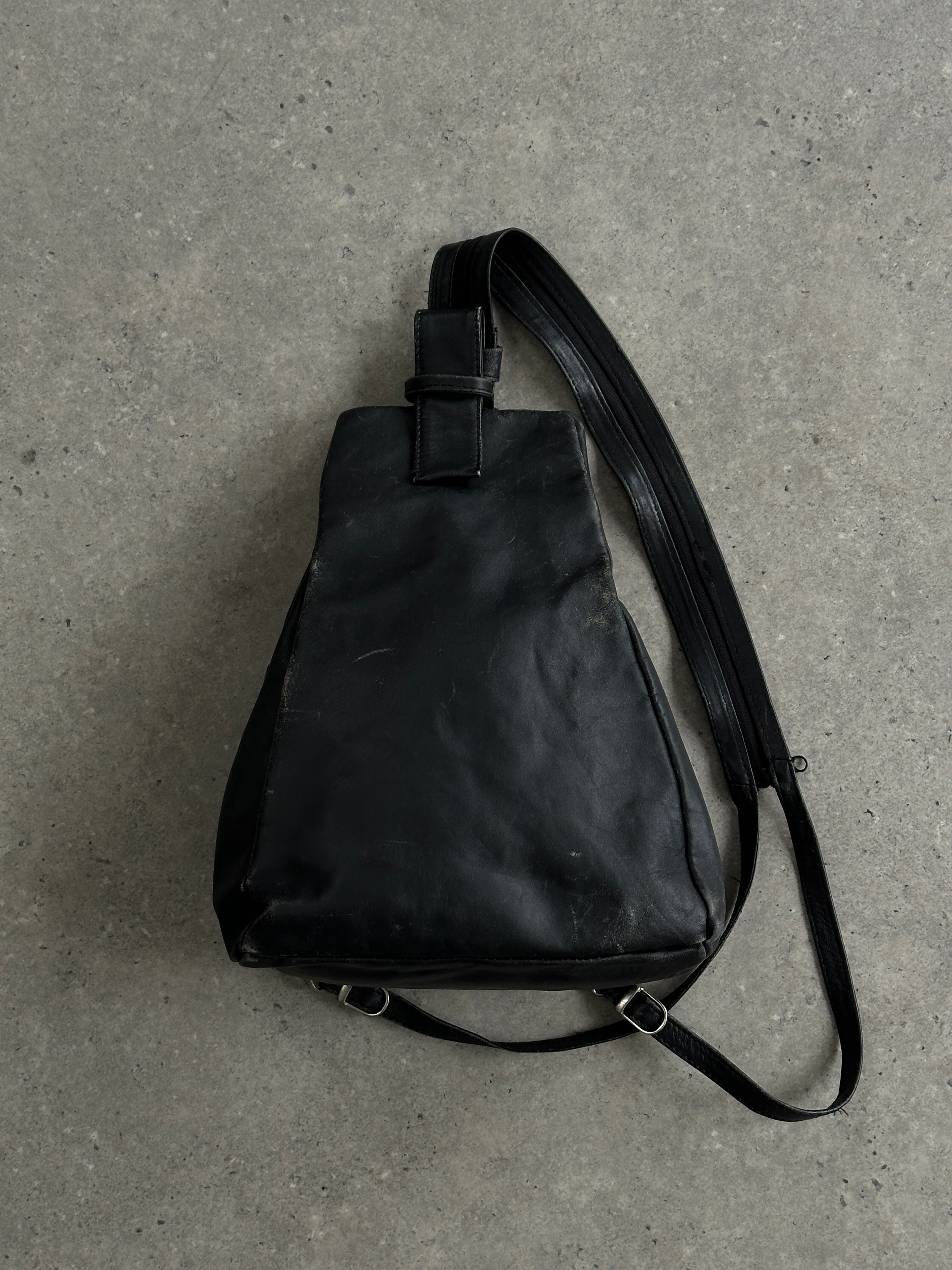 Vintage distressed faux leather rucksack crossbody bag with adjustable strap and vintage style, showcasing rugged, worn-in look.
