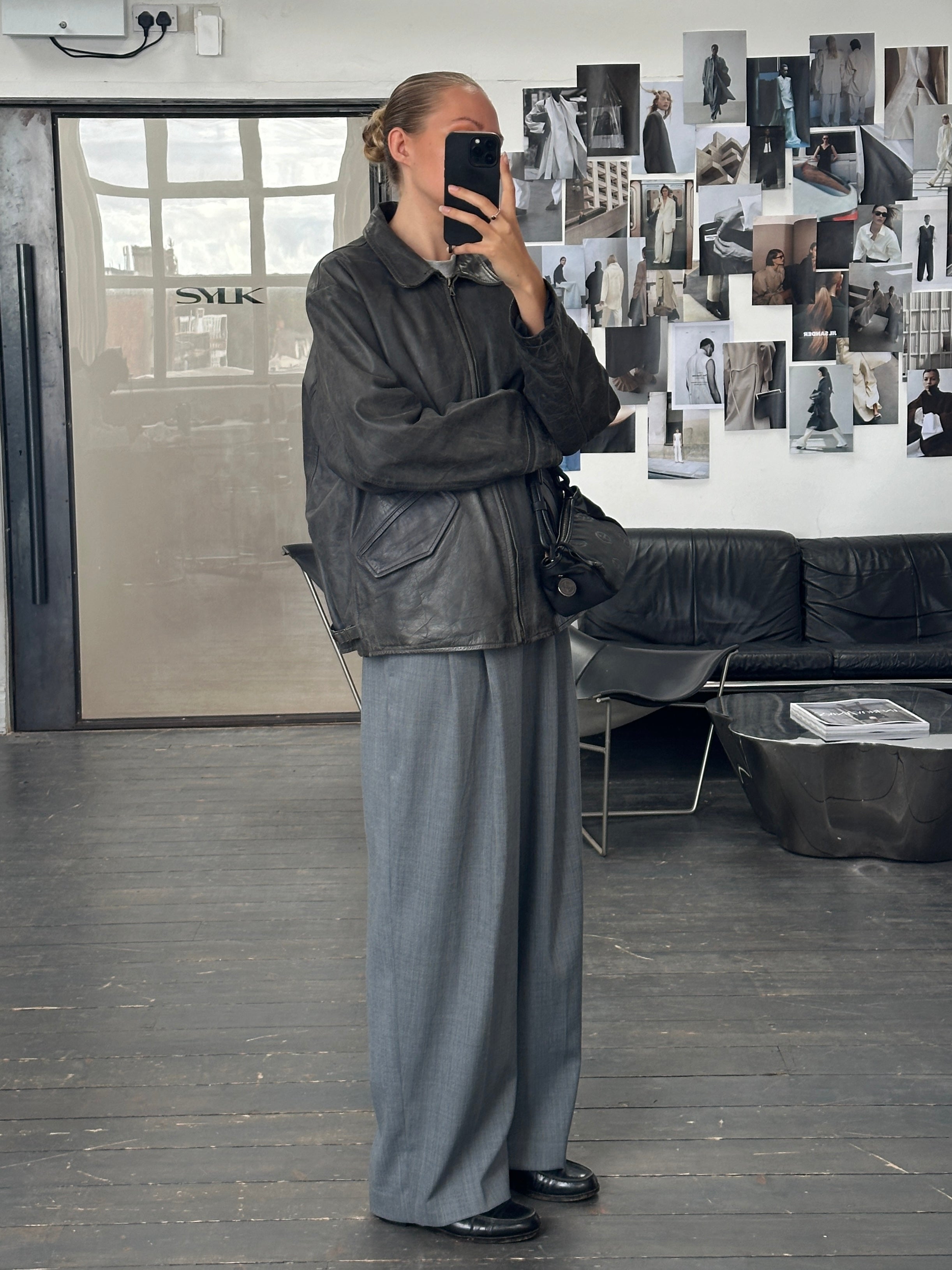 Vintage 1990s aged boxy leather jacket in size L/XL with distressed finish and classic design, displayed on a hanger.