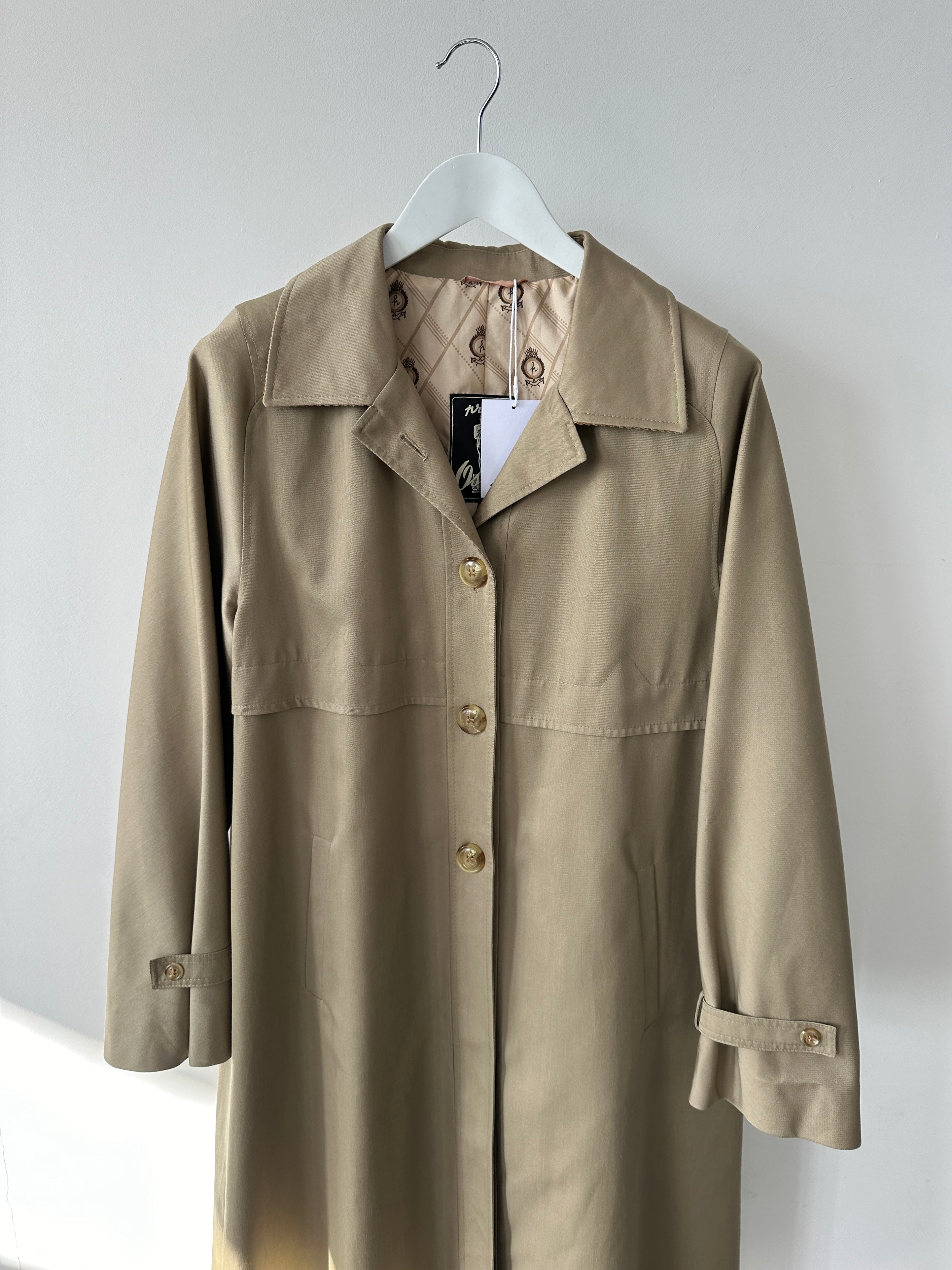Vintage single-breasted trench coat in size S, featuring classic design and neutral color, displayed on a hanger.
