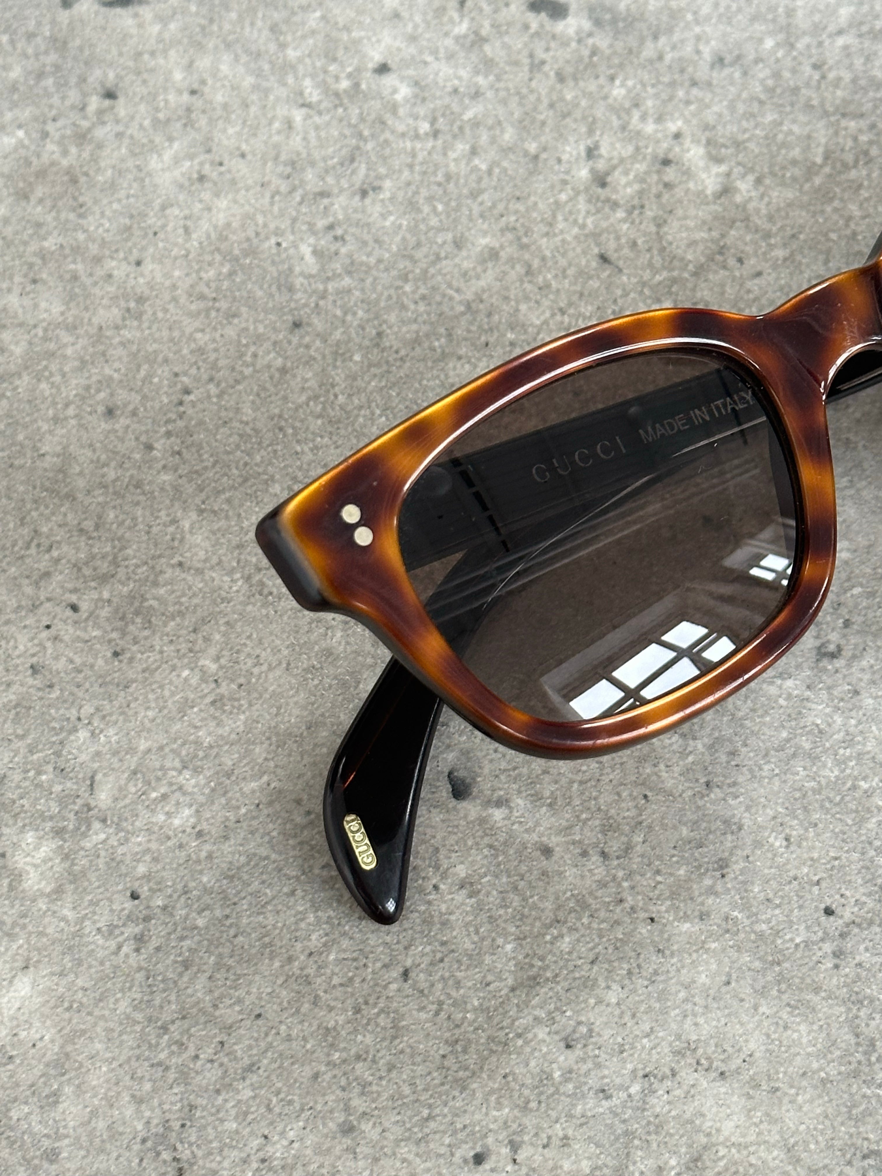 Gucci 2000s Tom Ford tortoiseshell rectangle logo sunglasses with bold frames and iconic branding.