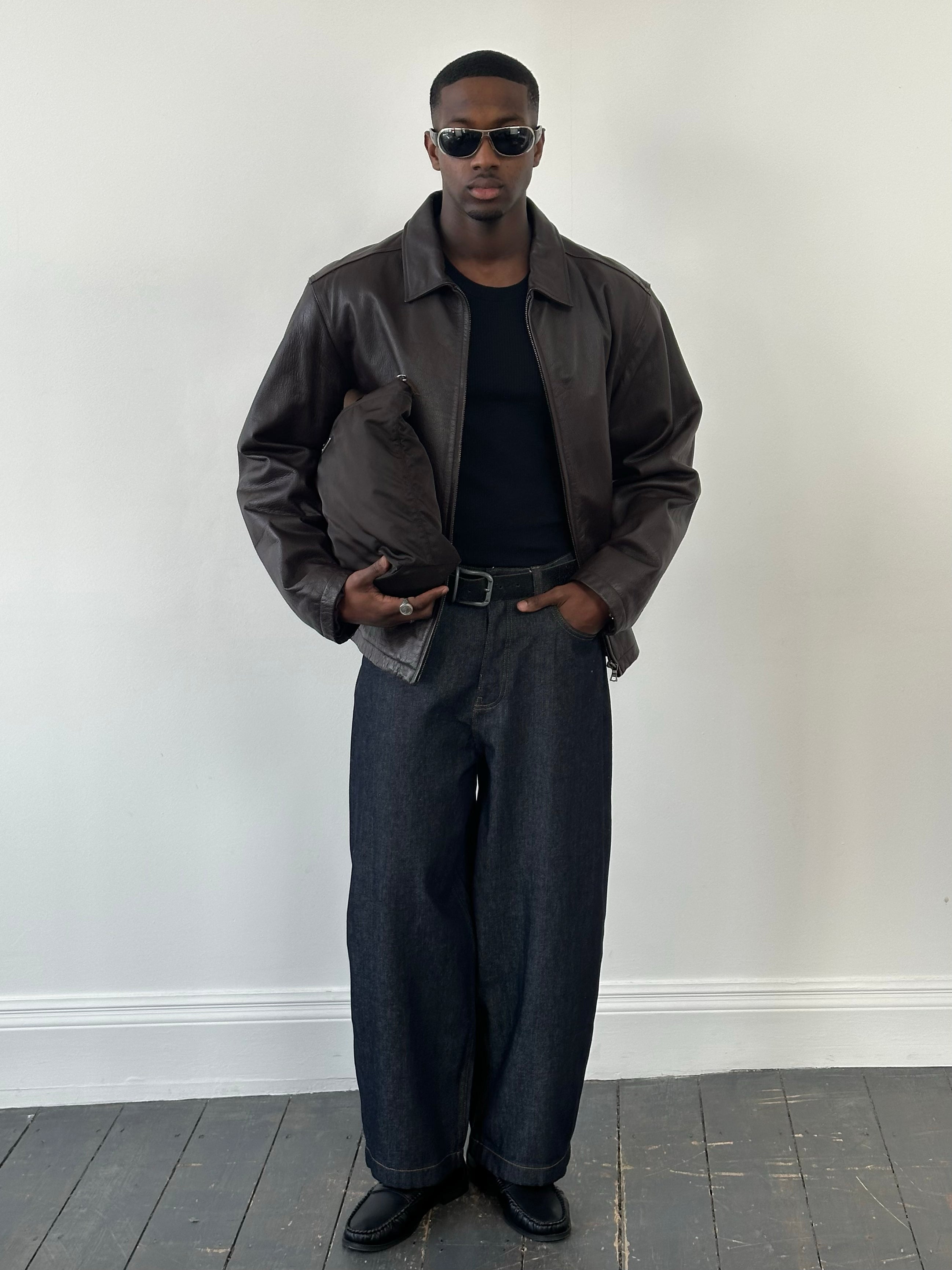 Vintage 1990s boxy leather jacket in XL with minimal design, featuring a classic collar and clean lines, shown on a hanger.